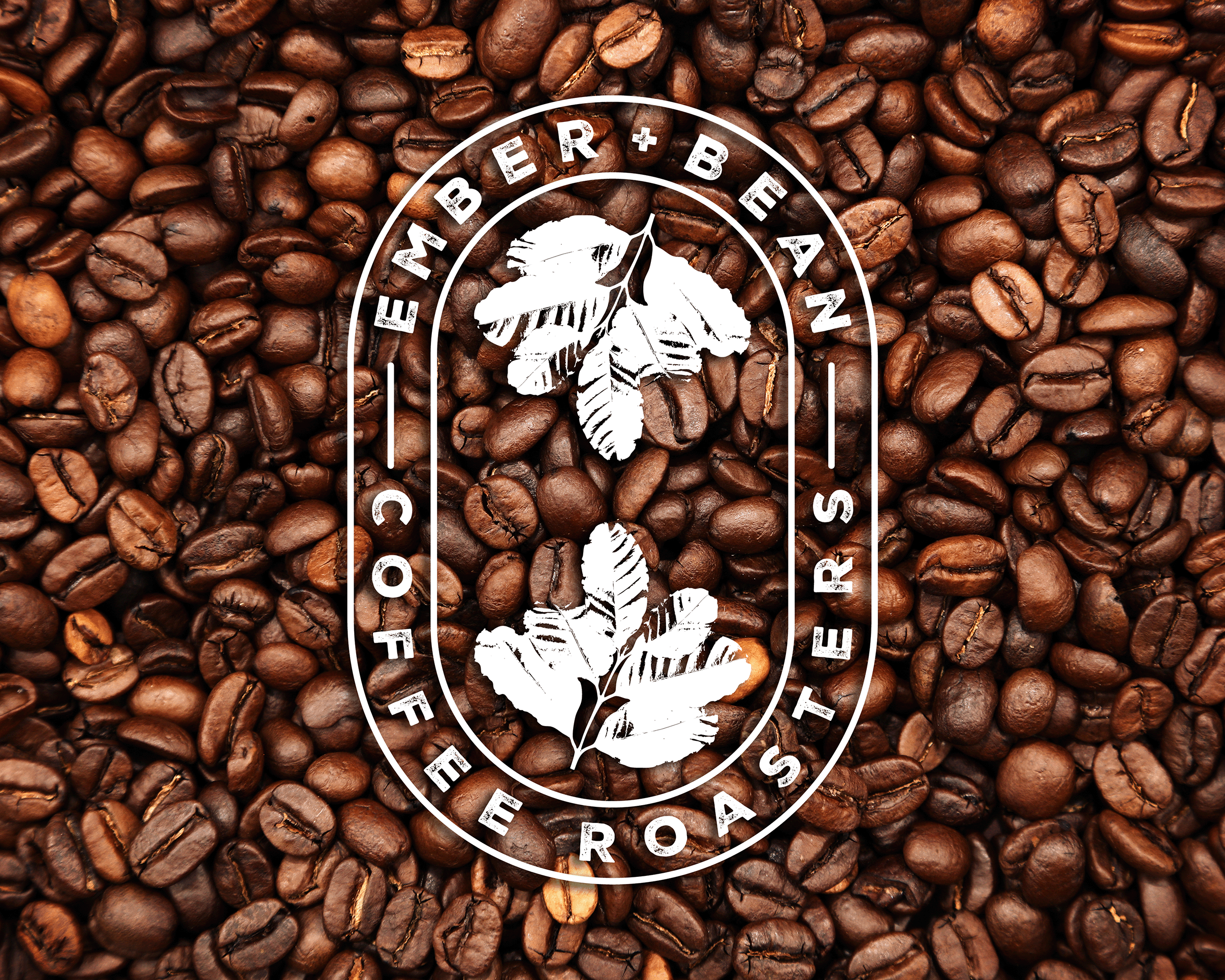 Logo for Ember + Bean Coffee Roasters in white on a background of coffee beans