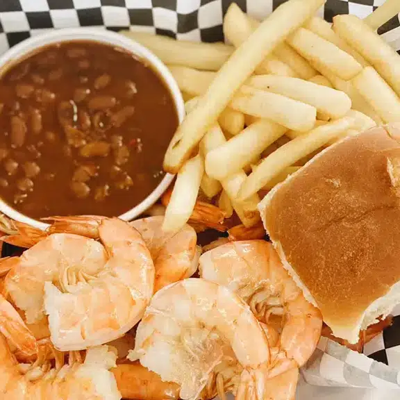 A basket of shrimp, fries, and beans.