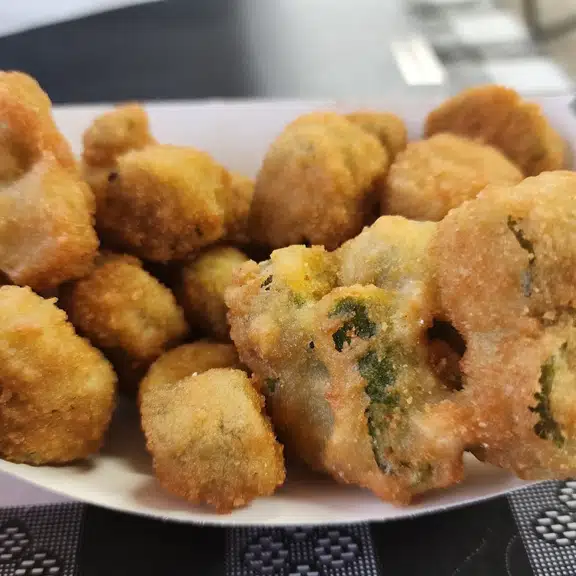 A white paper plate with a variety of food items on it.
