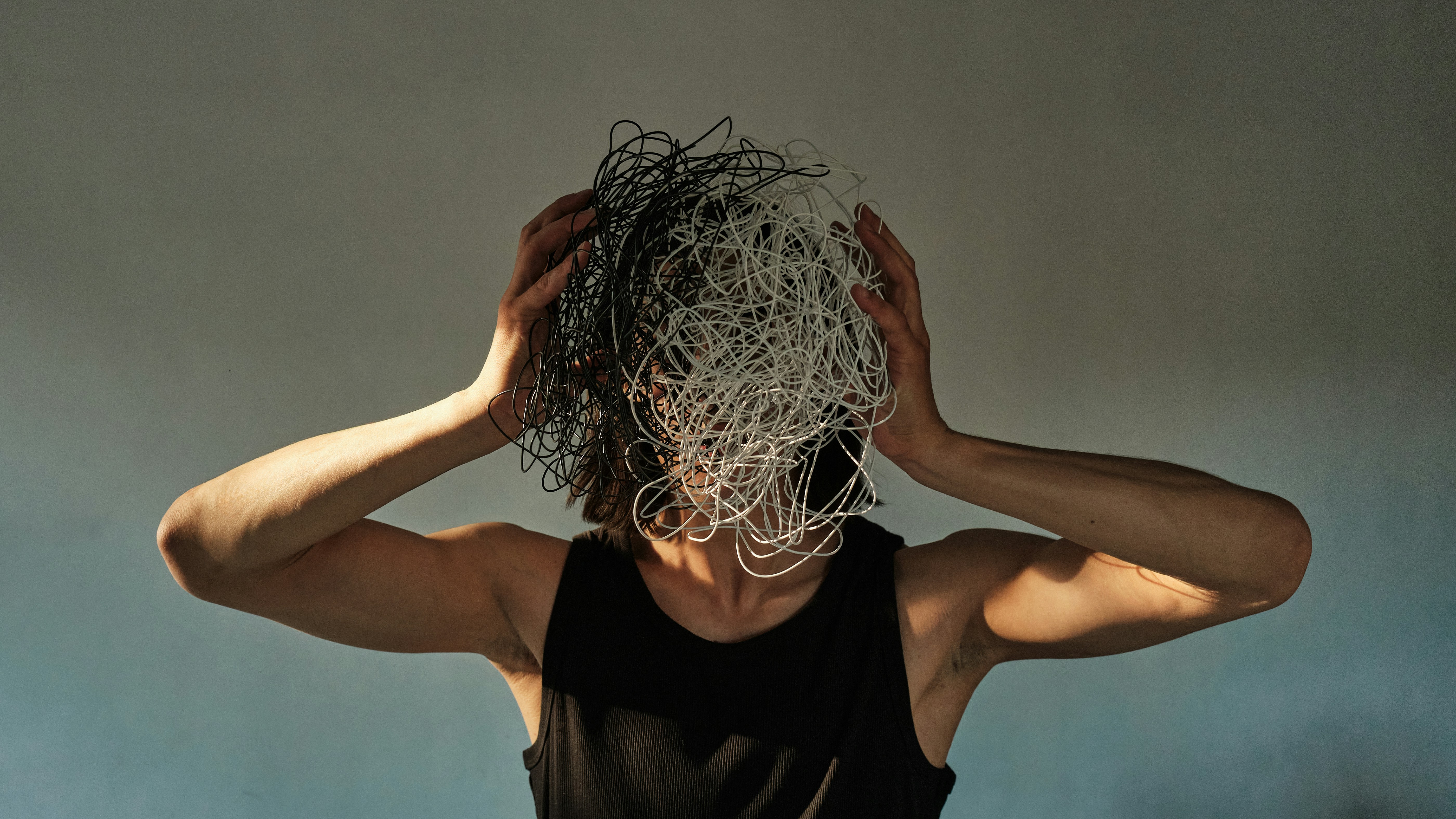 Person holding messy wire in front of their face representing anger and messy thoughts