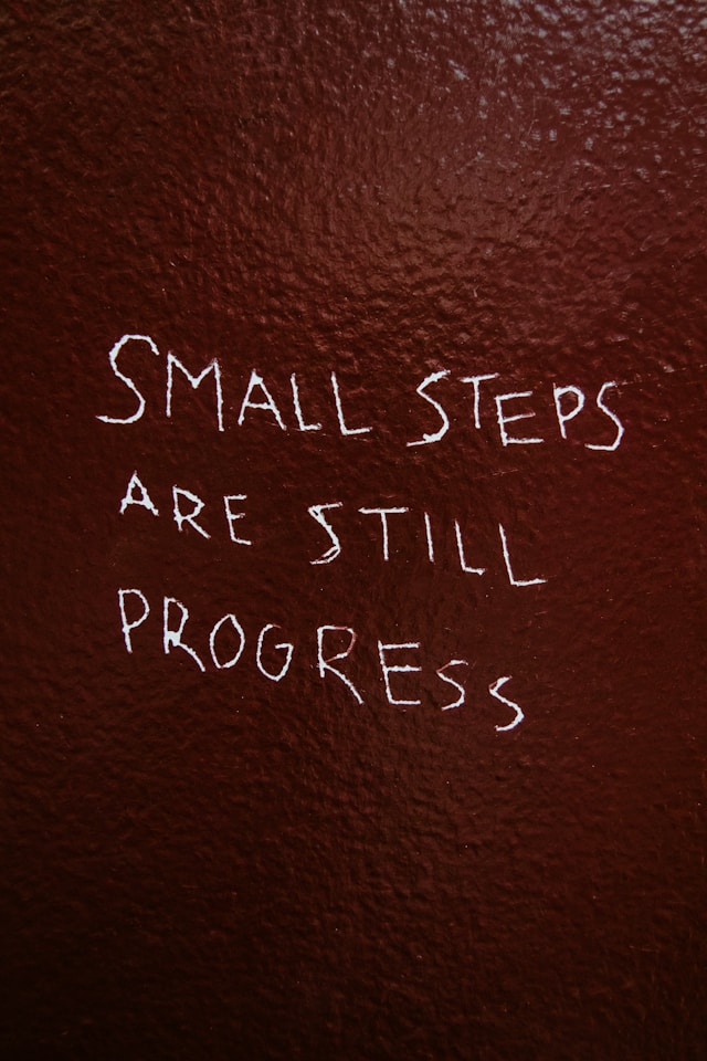 "small steps are still progress" etched into a wall