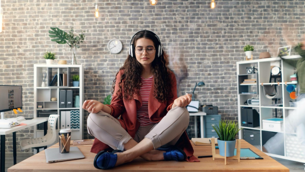 A girl meditates on her desk to help with her work anxiety.