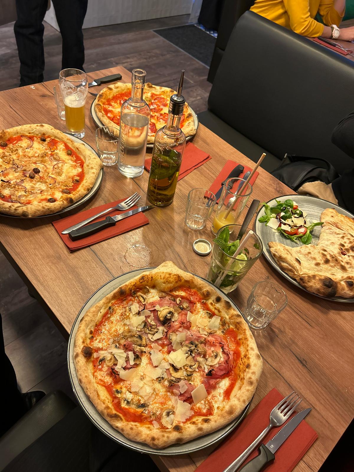 Thin pizza coming out from the oven