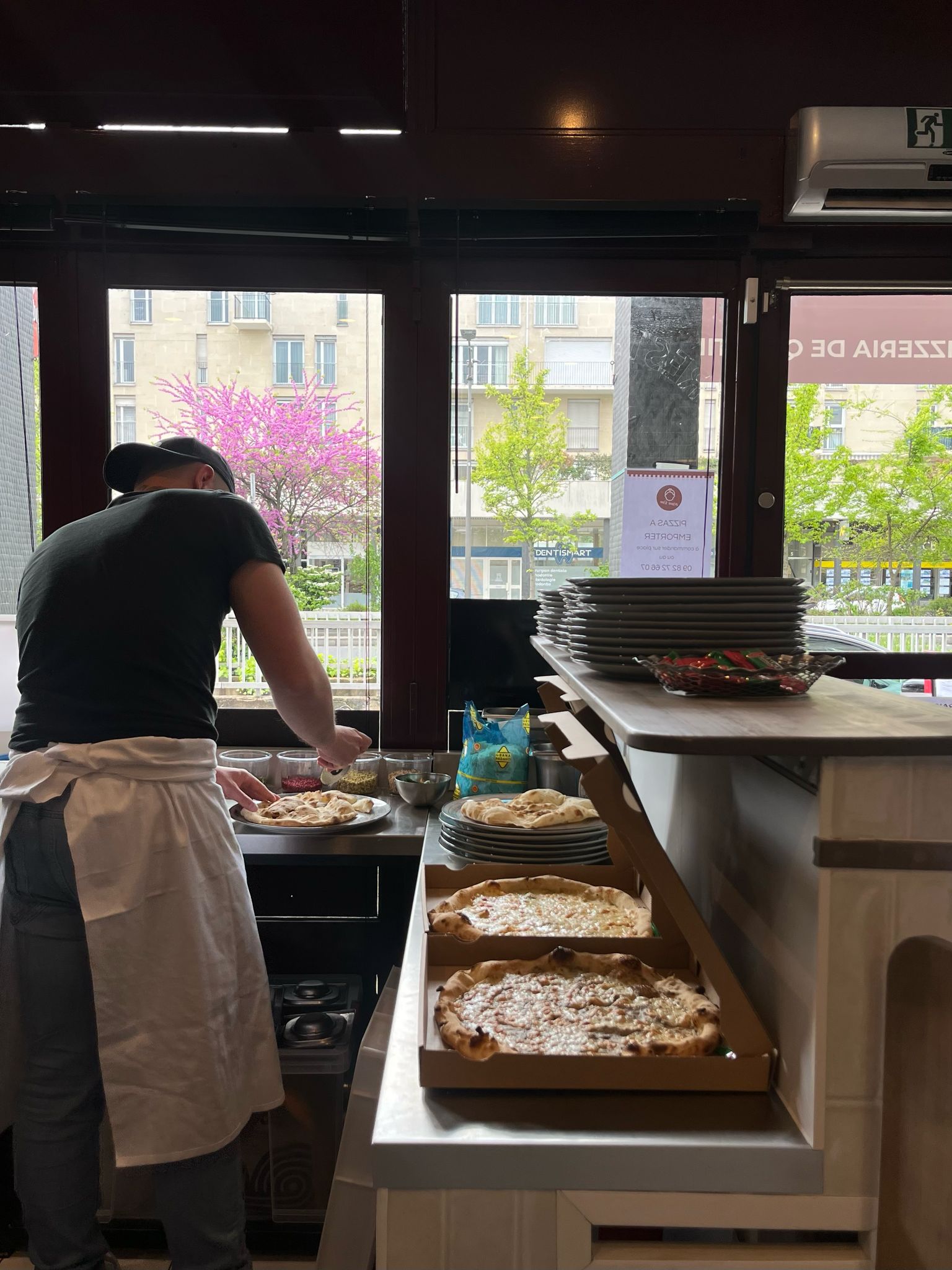 Chef placing cheese on raw pizza bread
