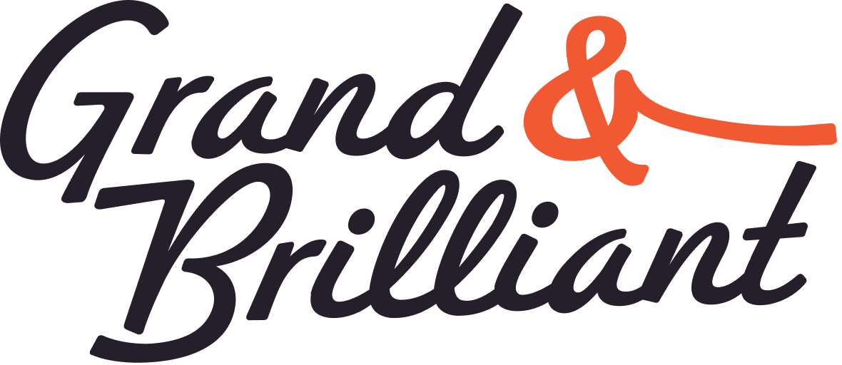 Logo with the words 'Grand & Brilliant' in black cursive script with an orange ampersand.