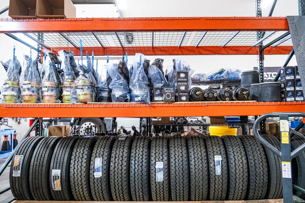 Heavy-duty truck parts inventory with tires and replacement components organized on warehouse shelves for fast repairs.
