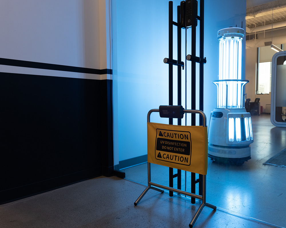 An automous UVC robot in action, behind a sensor controlled safety sign