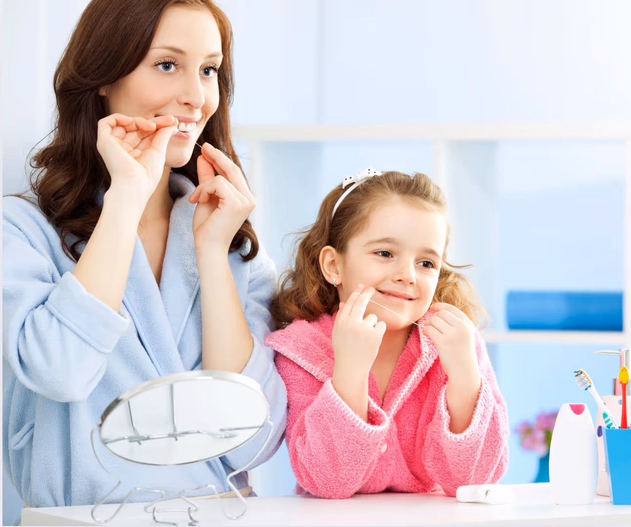 Mom and daughter flossing teeth