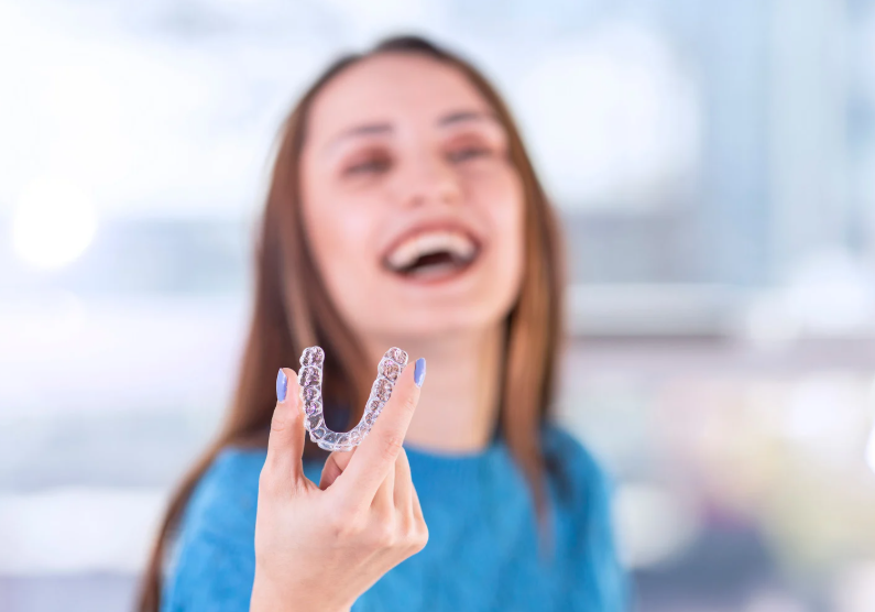 Woman smiling holding Invisalign
