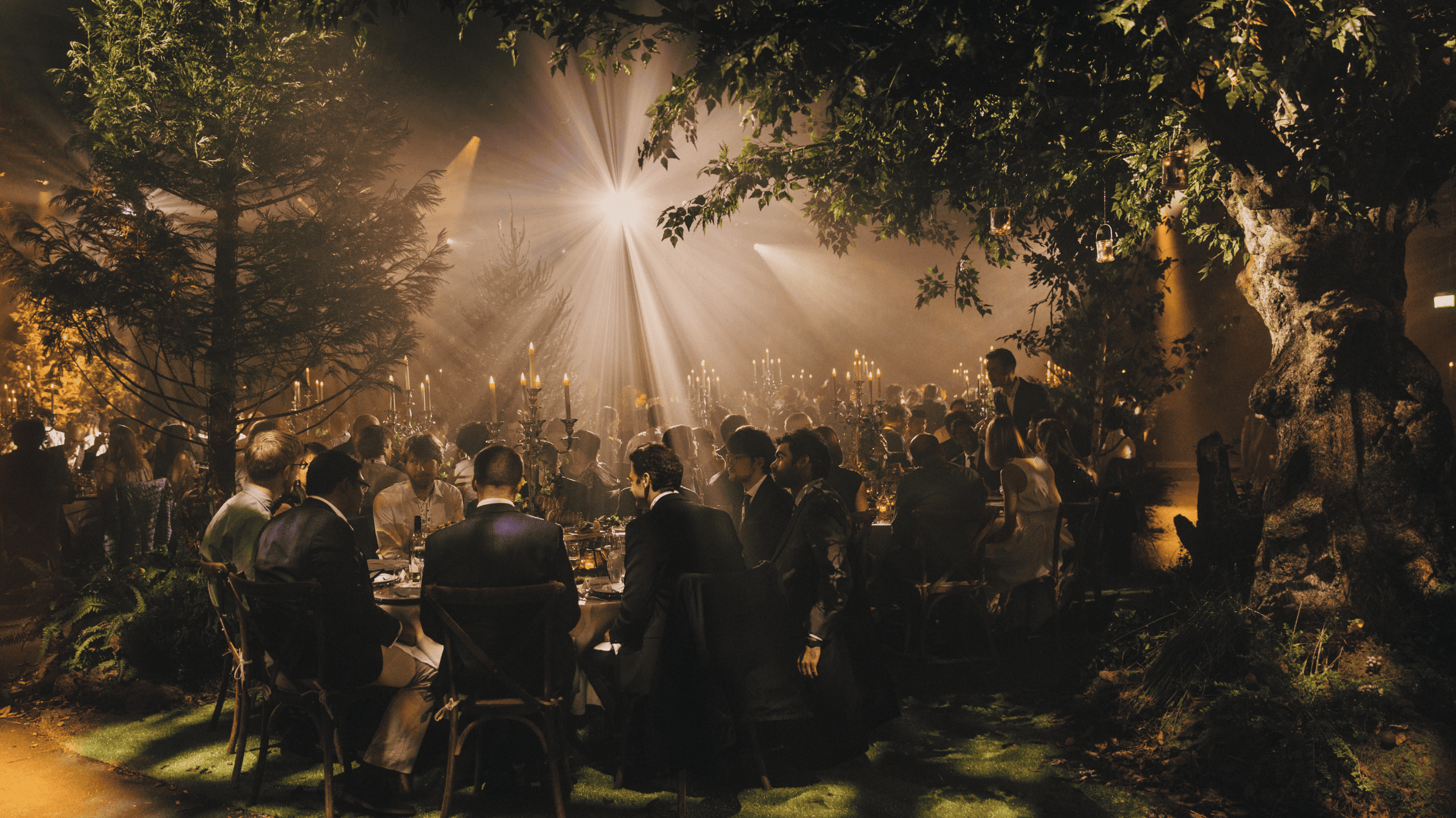 People walking through a forest illuminated by warm light at sunset for Keep Adventuring