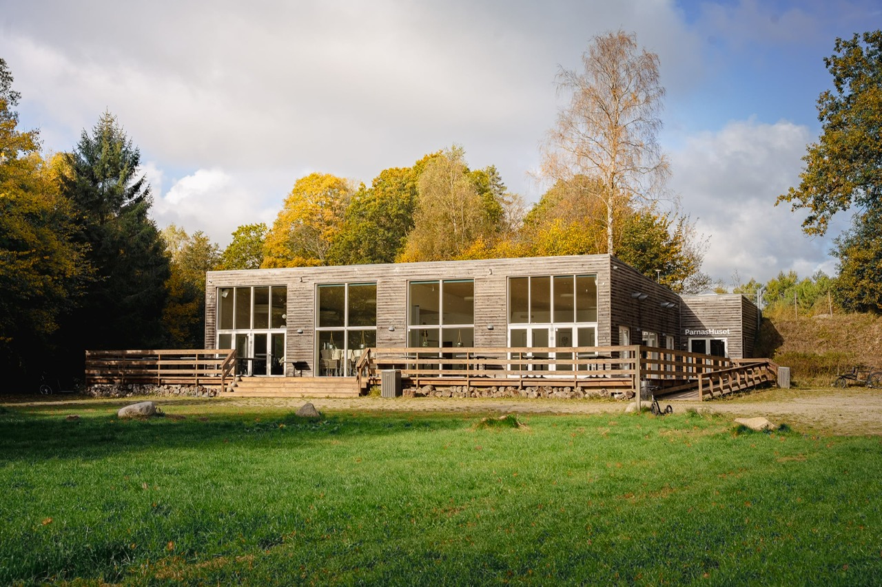 Billede af Parnashuset set udefra. Flot efterårsnatur ses i for- og baggrund. Parnashuset er velegnet til møder, kurser og konferencer.