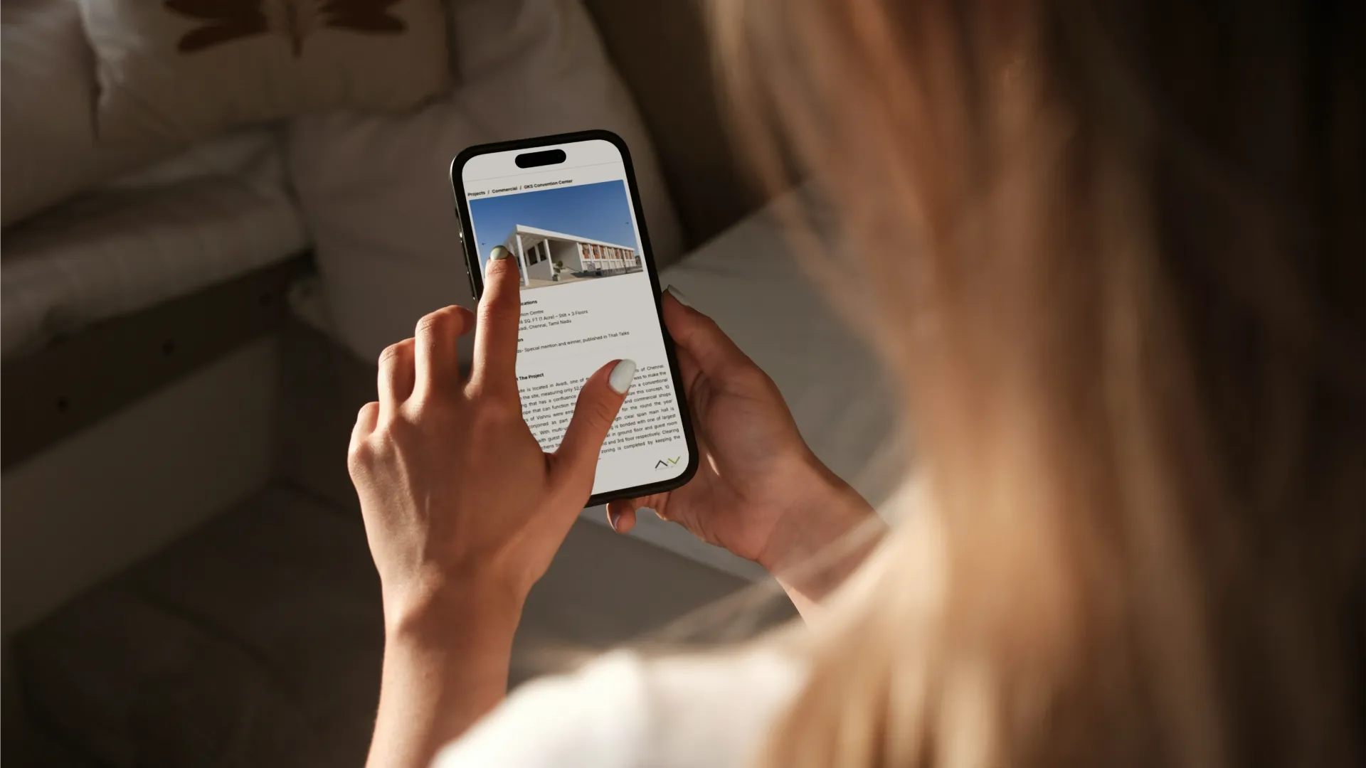 Modern girl viewing Architecture plus Value's website designed by concreate on her iPhone.