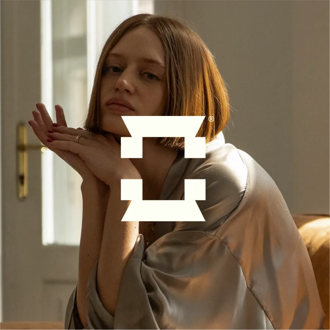 Female model sitting on a couch as a background element for Celadon Imagery's brand identity.