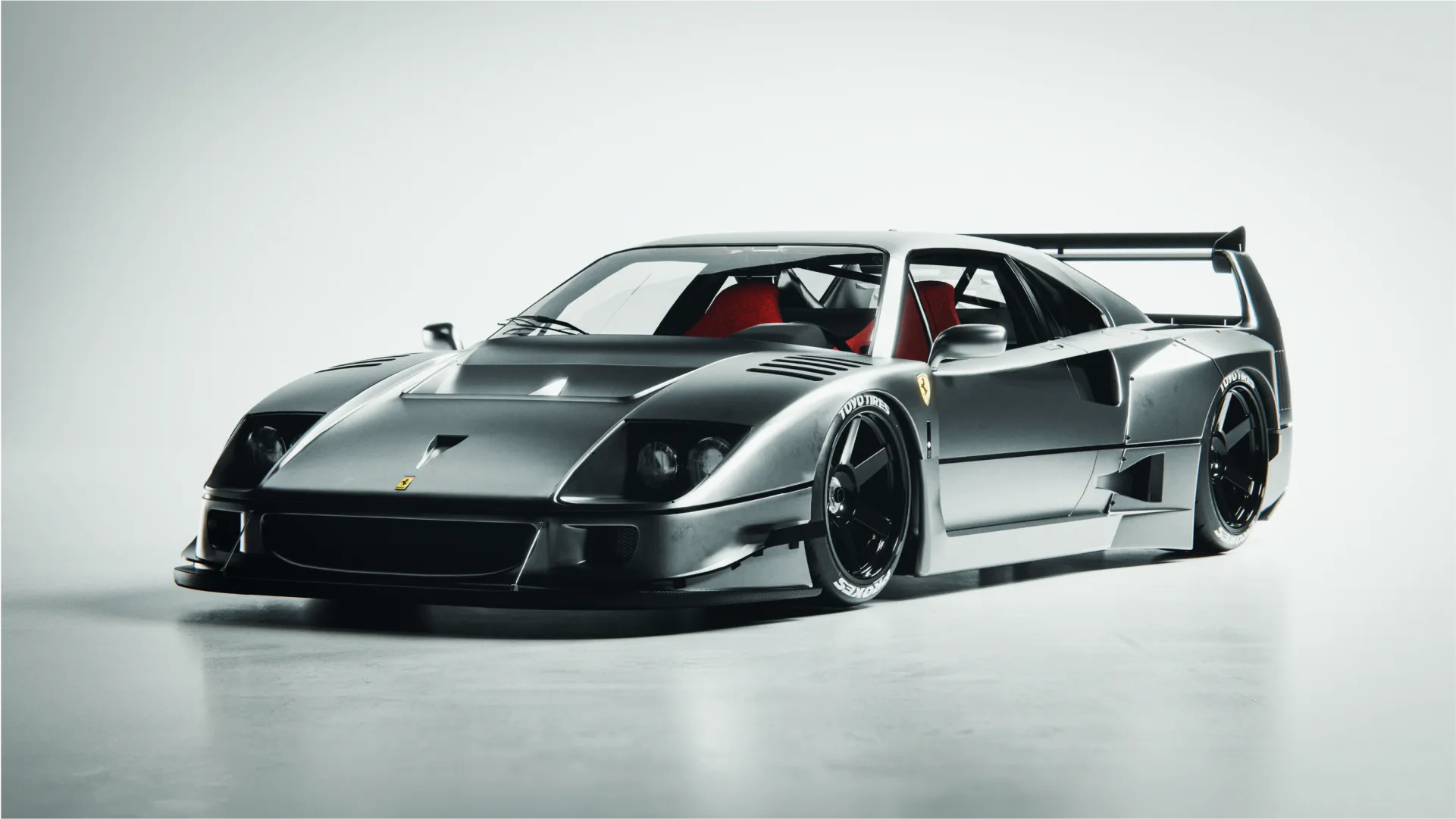 A Ferrari in metallic grey finish in a studio backdrop setup.