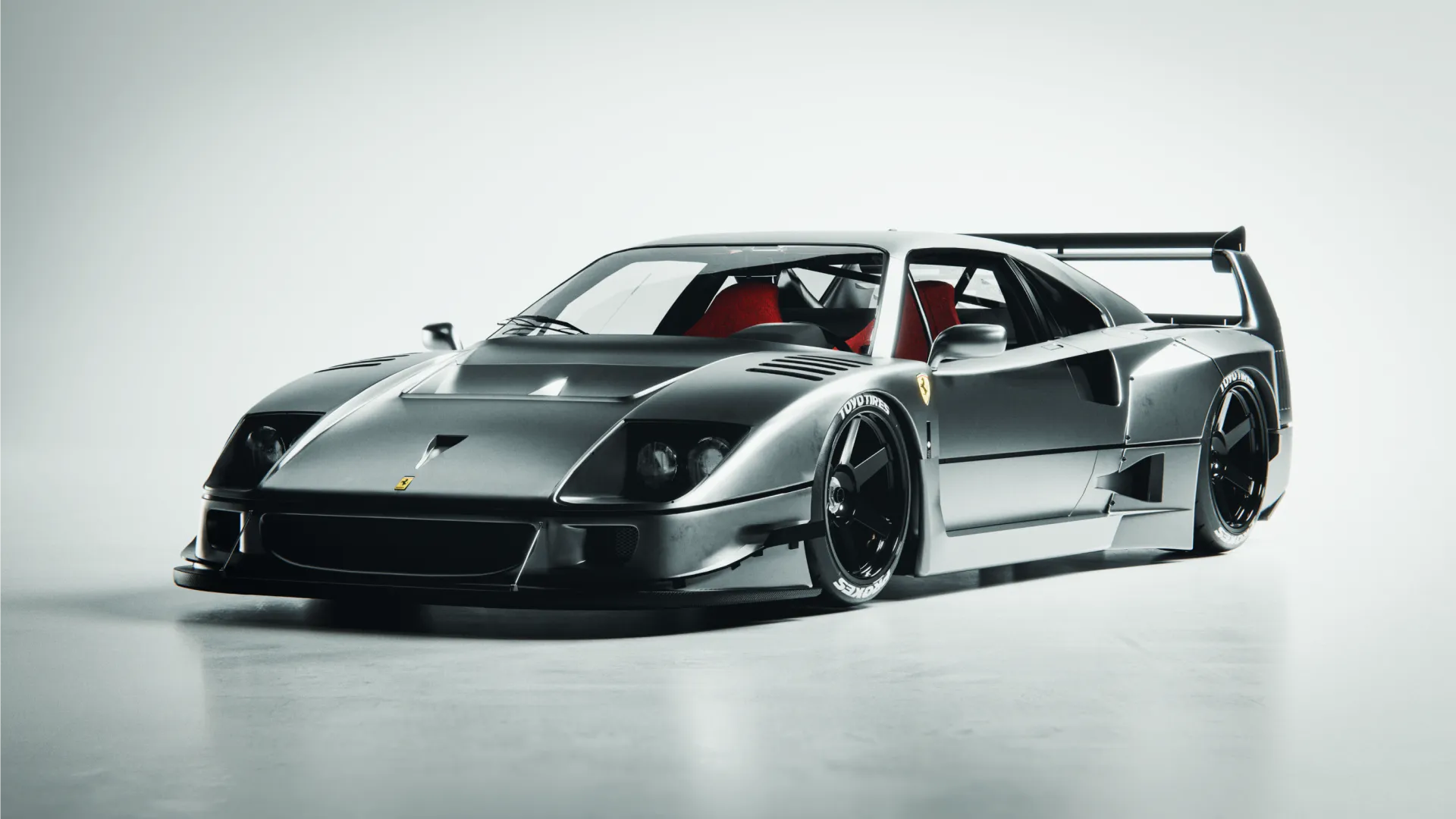 A Ferrari in metallic grey finish in a studio backdrop setup.