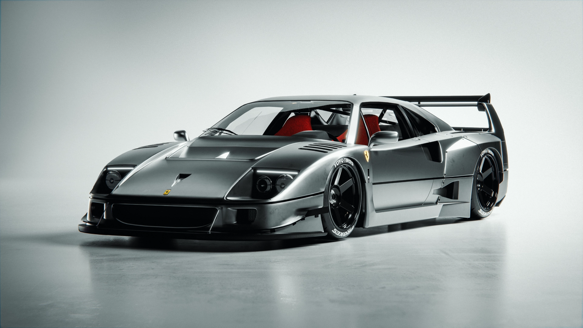 A Ferrari in metallic grey finish in a studio backdrop setup.