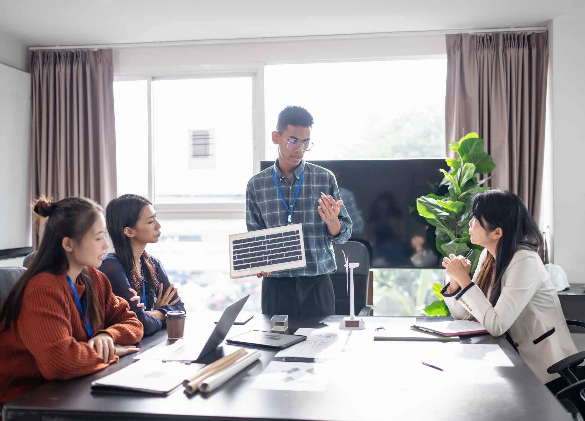 Apresentação de proposta de energia solar por vendedor para equipe comercial em sala de reunião