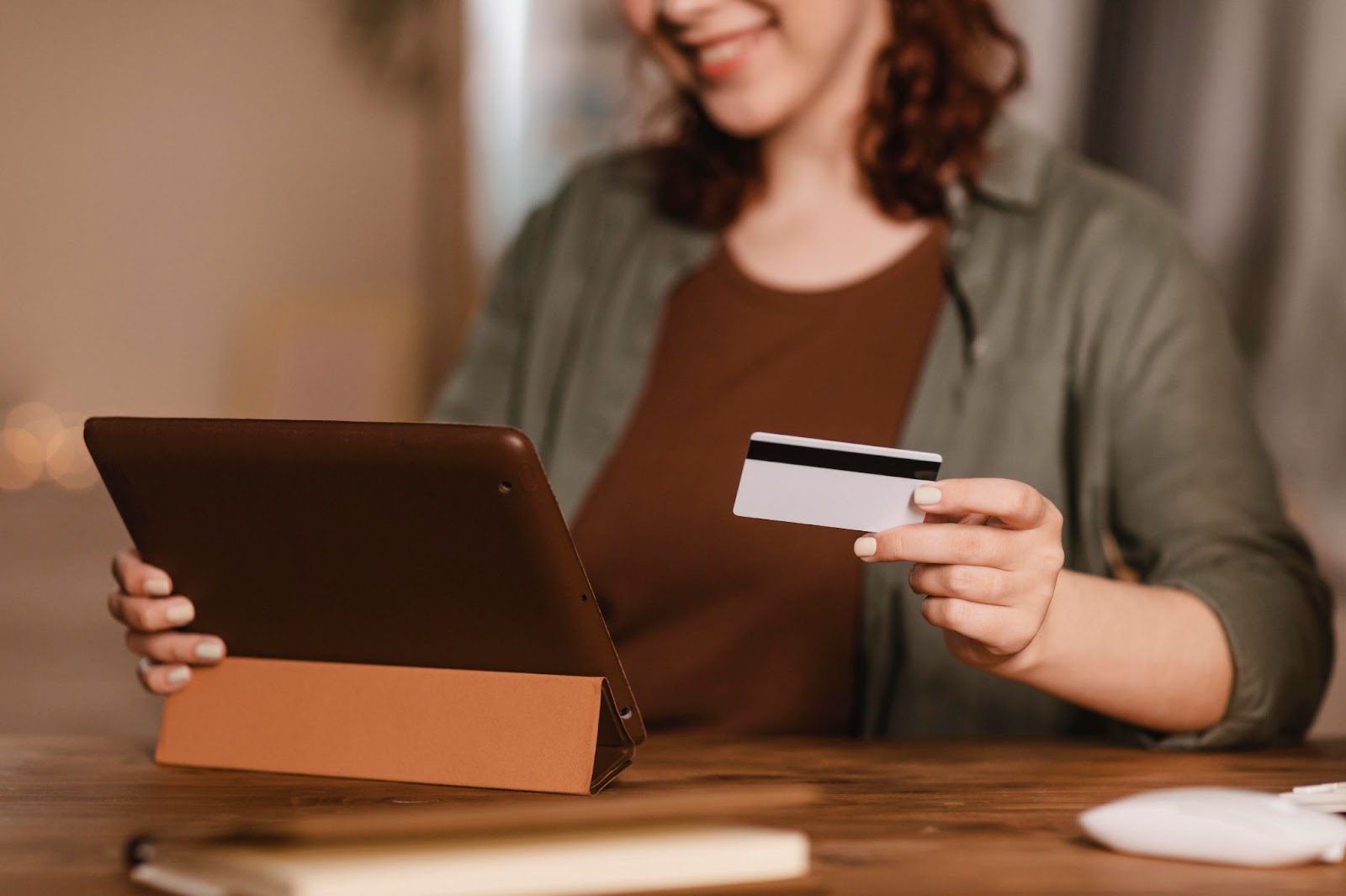 woman holding credit card and tablet