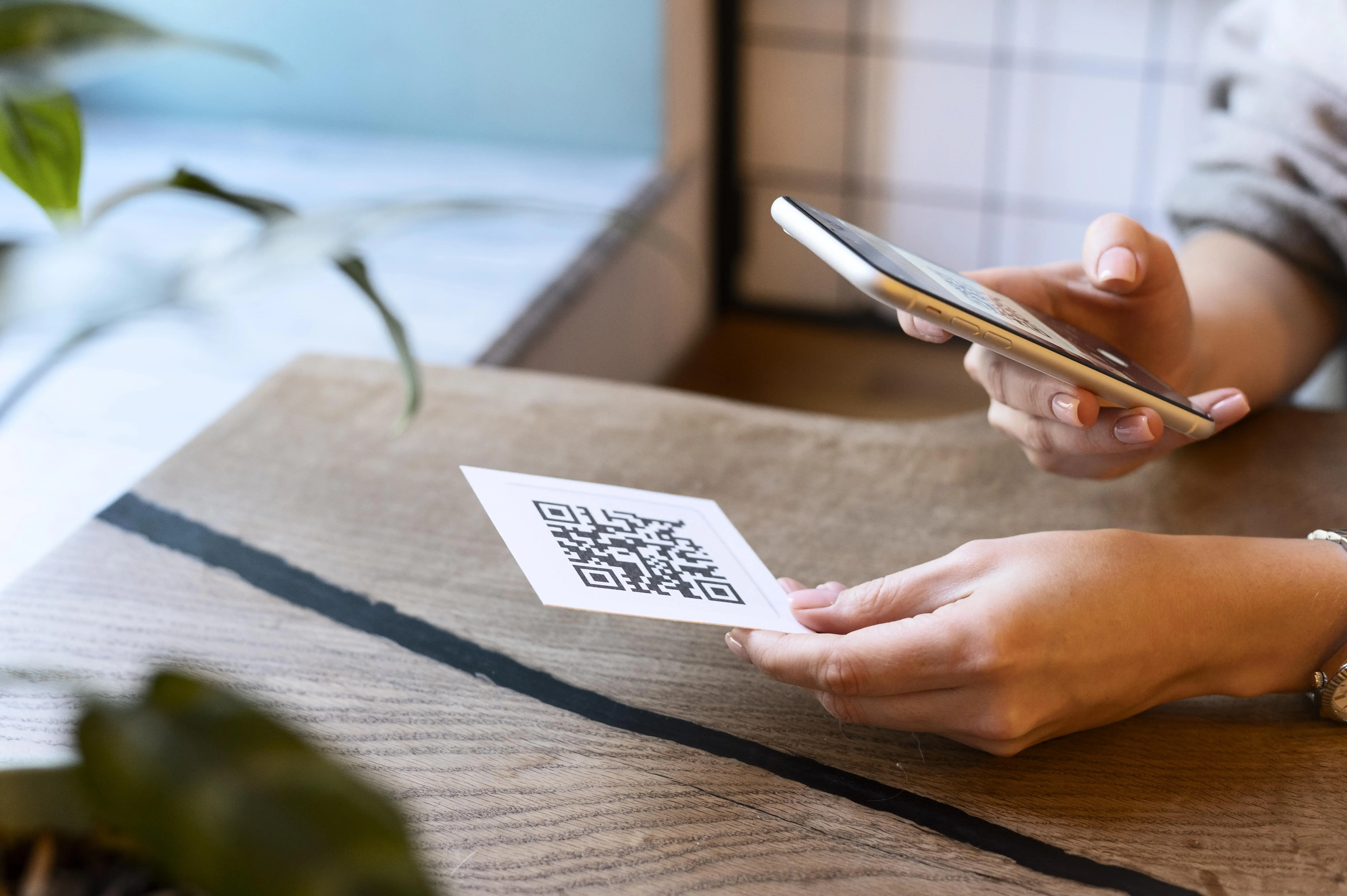 Person scanning QR code with smartphone for mobile payment