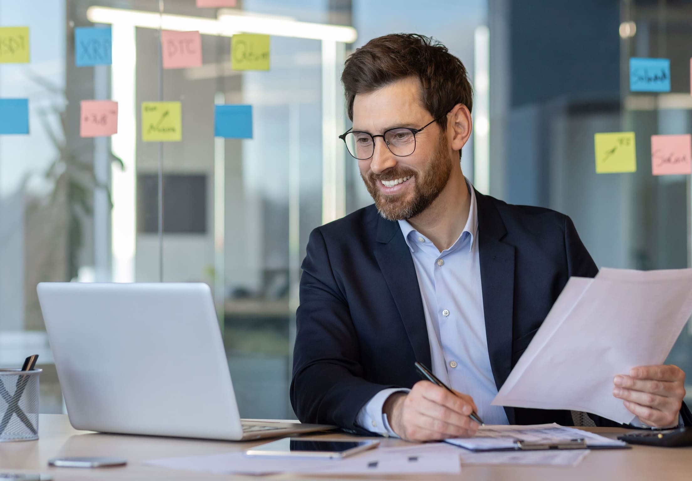 Un membre de L’Agence Web Nantaise travaillant sereinement sur son ordinateur, documents en main.