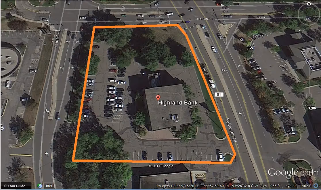 Aerial view of bank surrounding by parking and busy roads