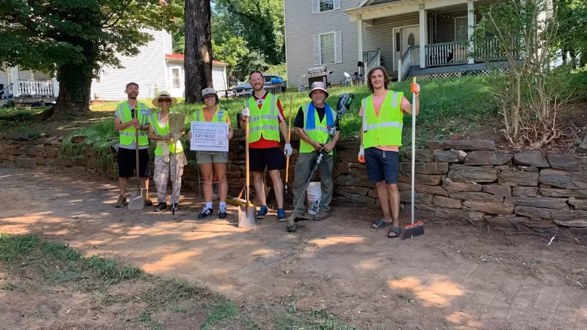 Group picture of volunteers in high visibility vests with tools