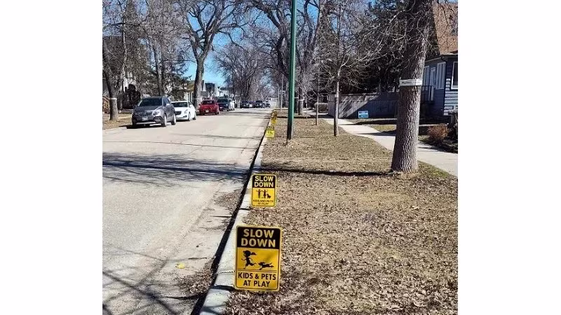 Sidewalk with lawn signs saying slow down kids and pets at play