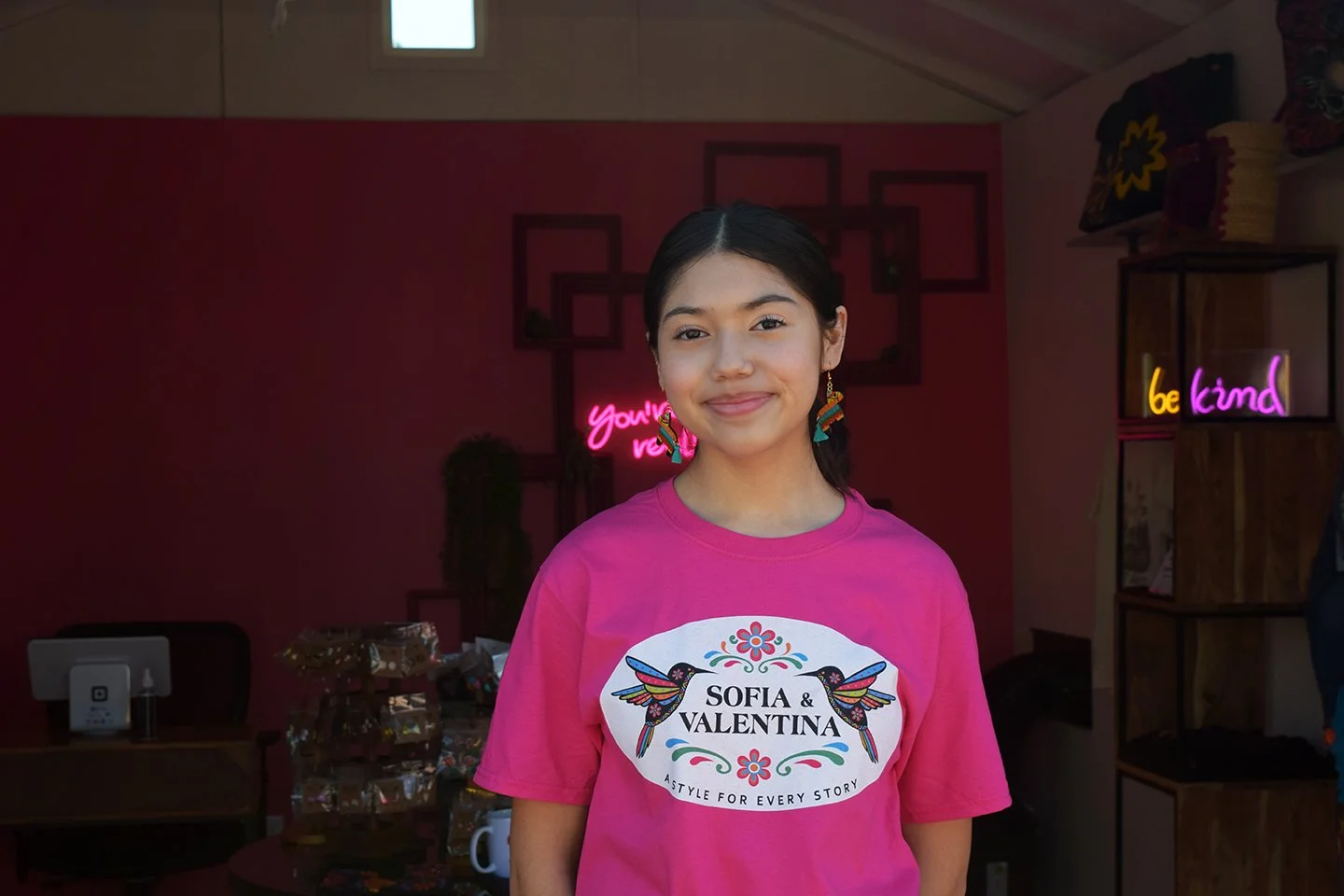 A vendor standing proudly in front of her shop.