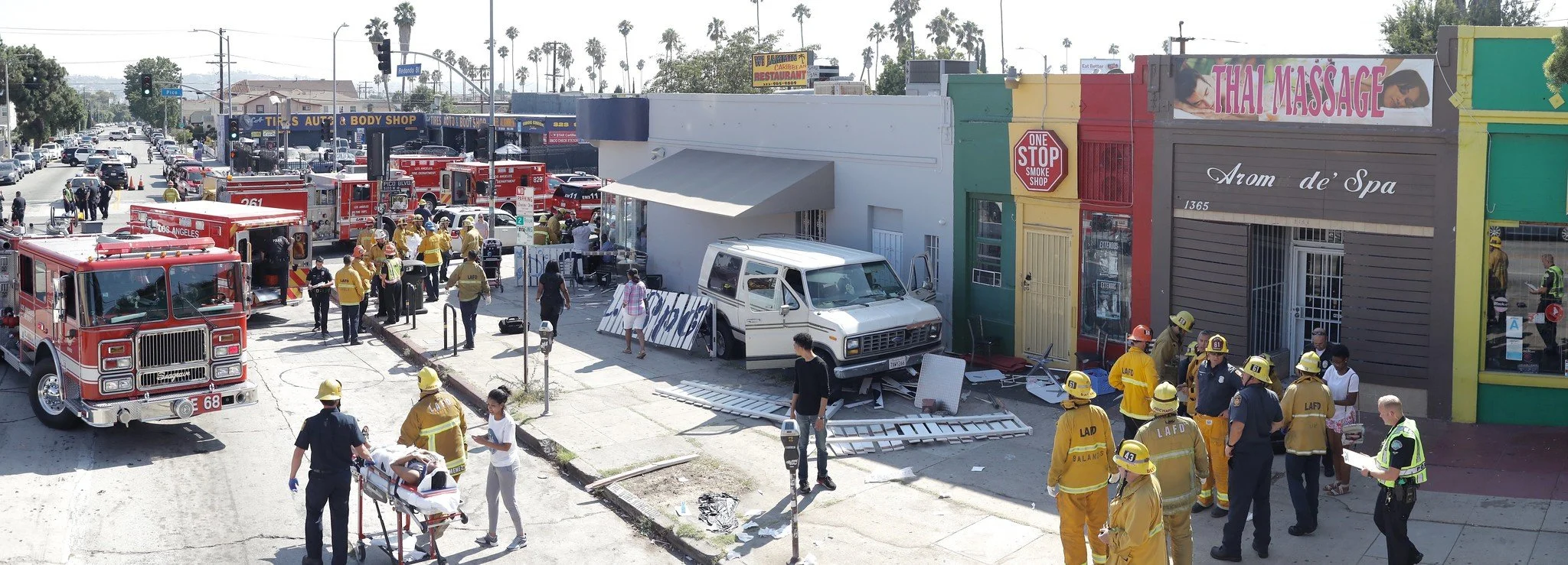 Fire trucks block the street as firefighters attend to people injured in a crash.