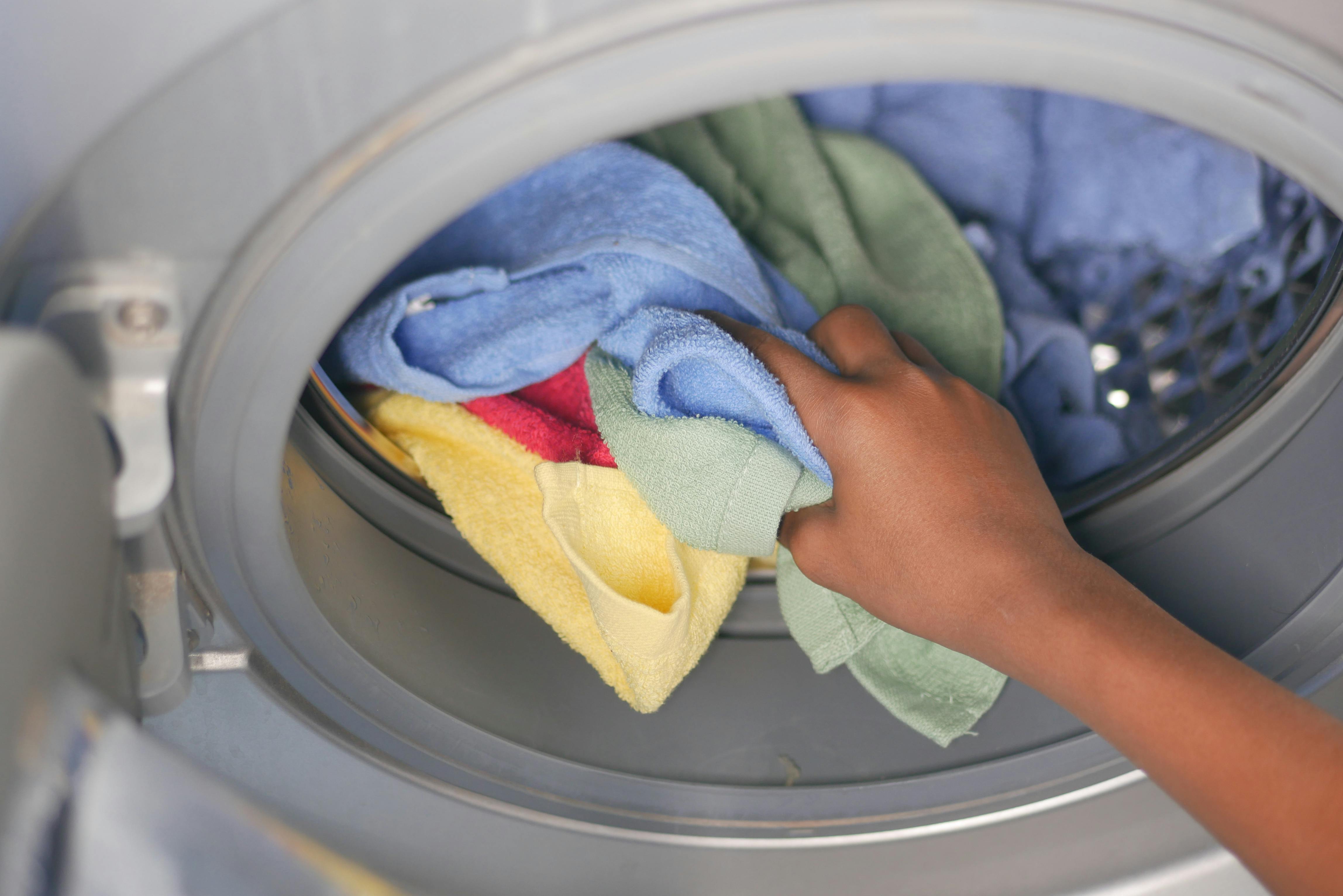Laundry machine with hand holding towels stock image