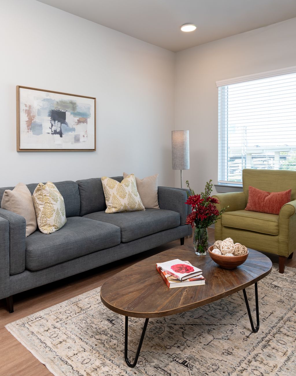 Living room with sofa, coffee table, wall art, and large window