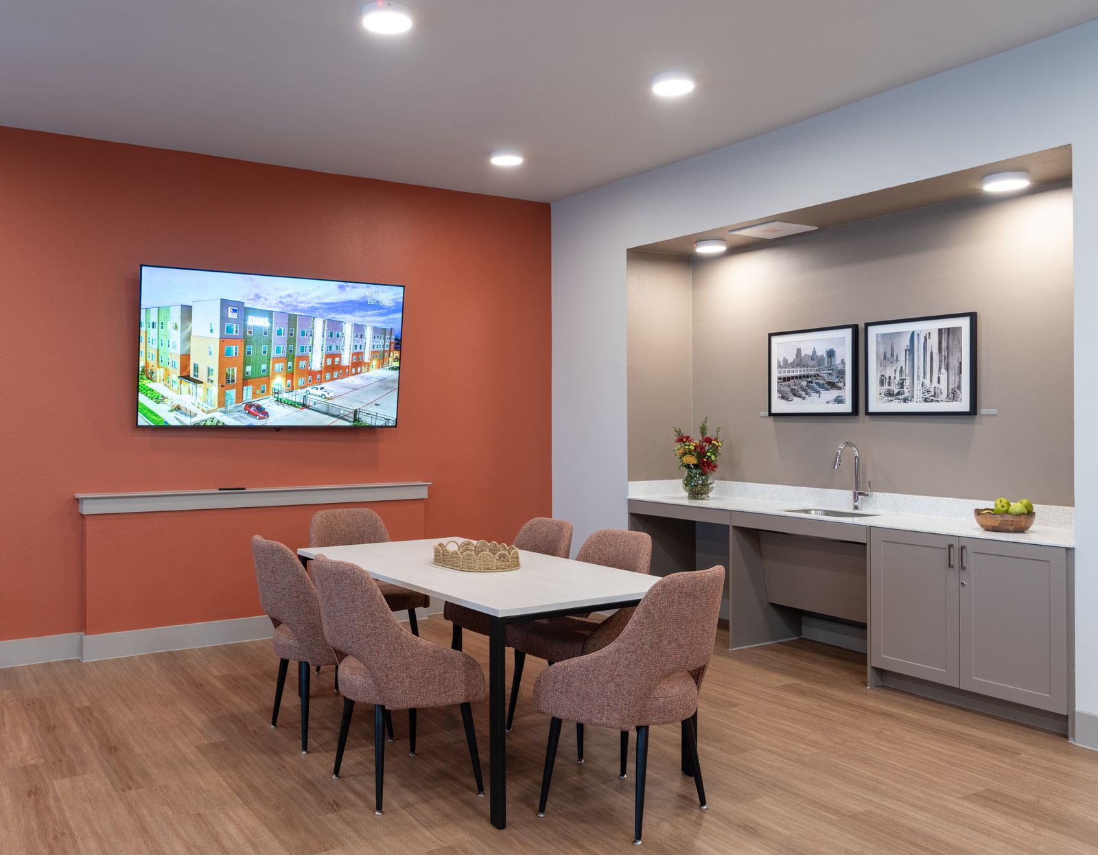 Wide view of community room with table and chairs and bar