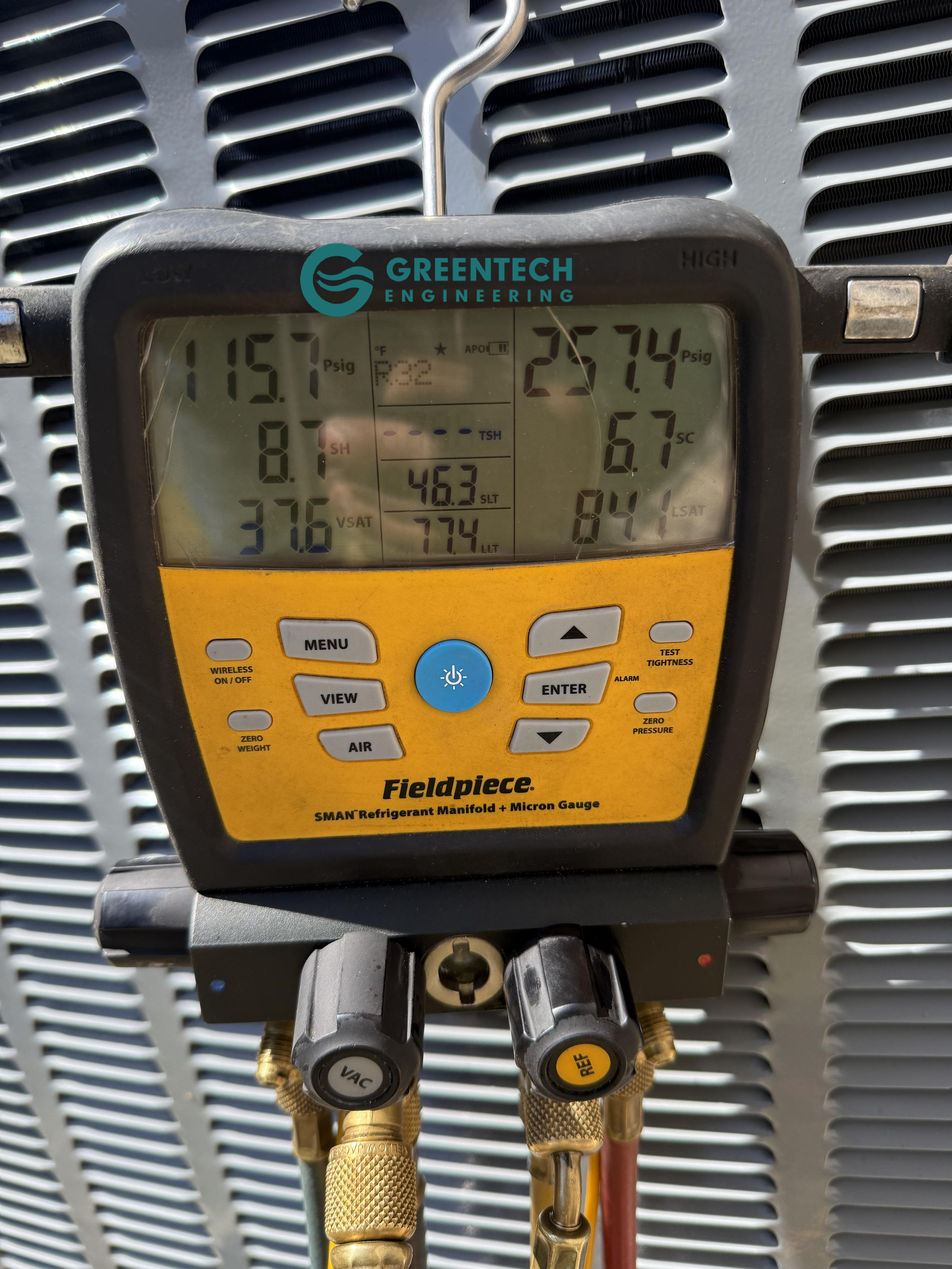Fieldpiece digital manifold gauge attached to a new Daikin air conditioning condenser, displaying precise refrigerant pressures and temperatures in the field.