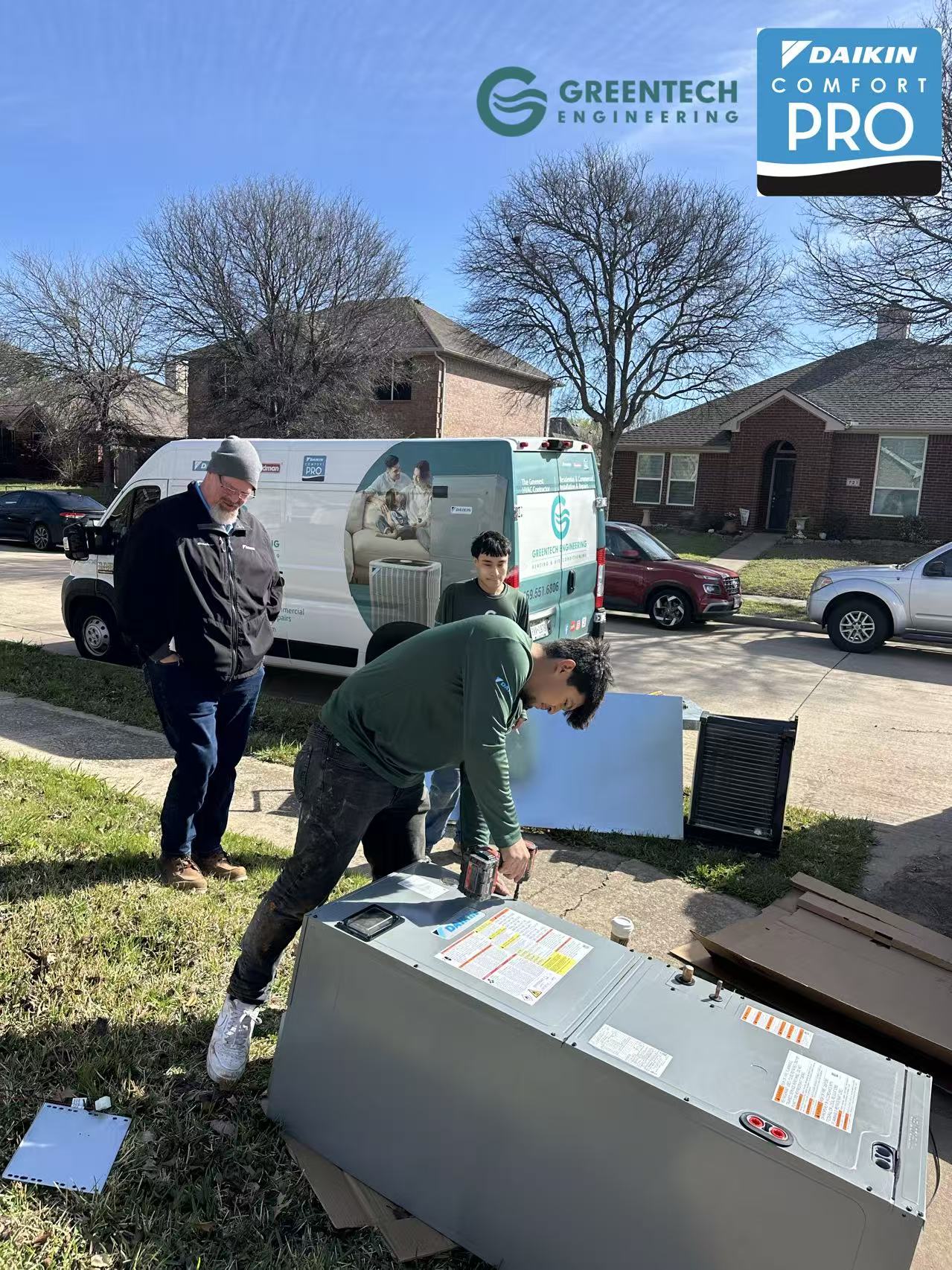 Greentech Engineering technicians pre-assembling a Daikin air handler and evaporator coil on a driveway before attic installation.