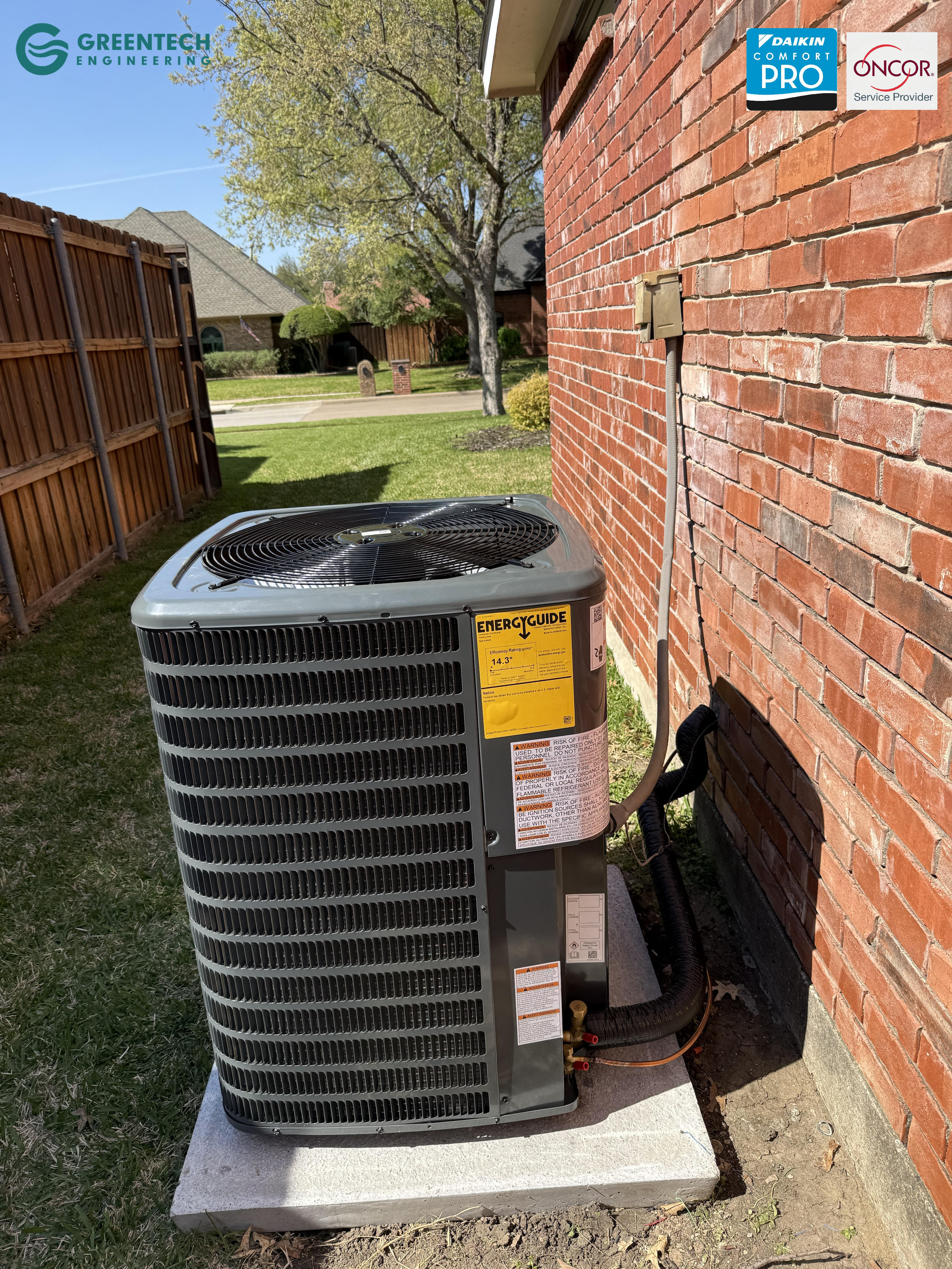 Newly installed Goodman 15.2 SEER2 air conditioning condenser on a new concrete equipment pad by Greentech Engineering in Grand Prairie, TX.