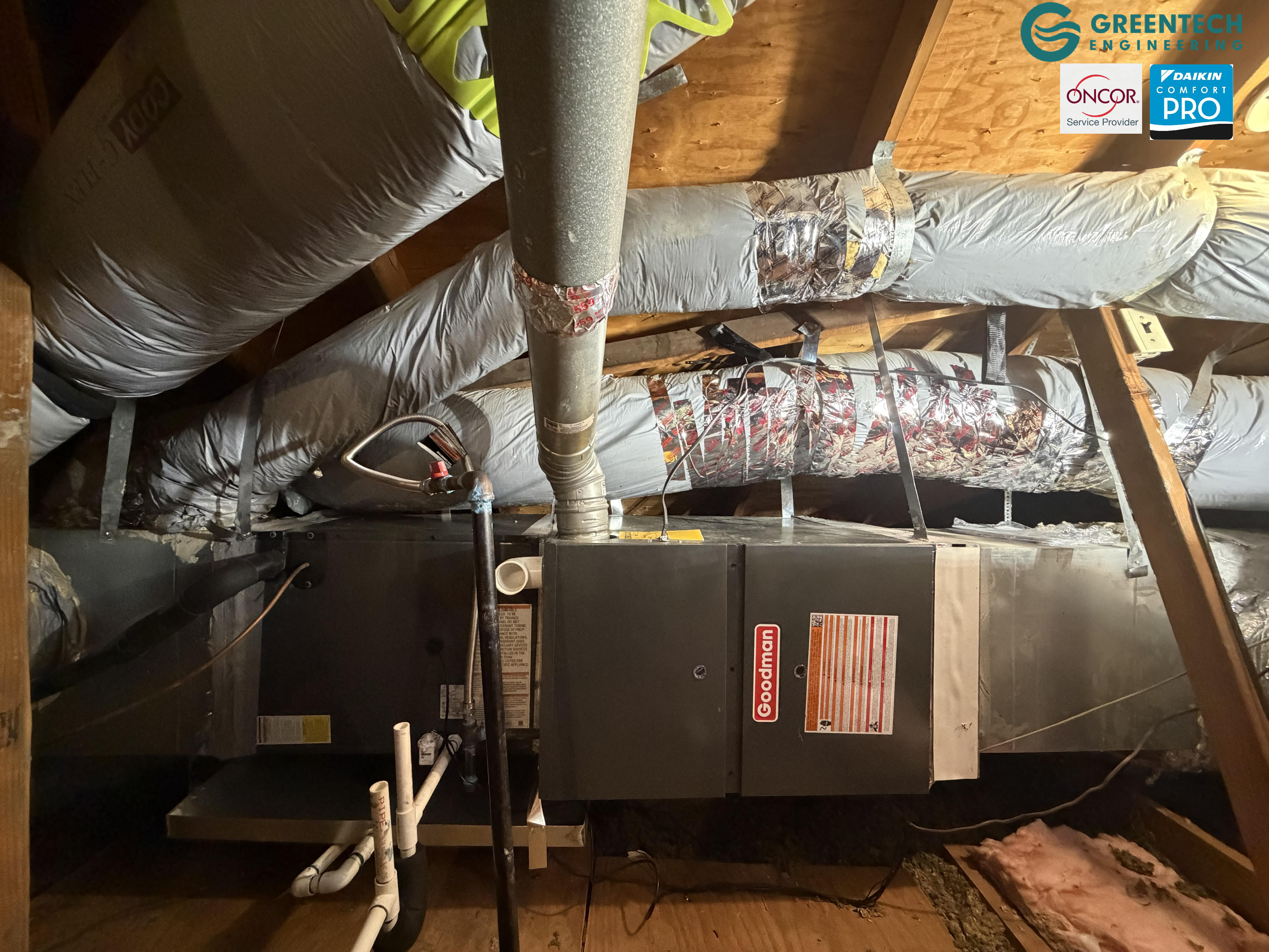 A newly installed Goodman gas furnace and cased coil suspended in a Plano attic, connected to freshly sealed ductwork and a new gas sediment trap.
