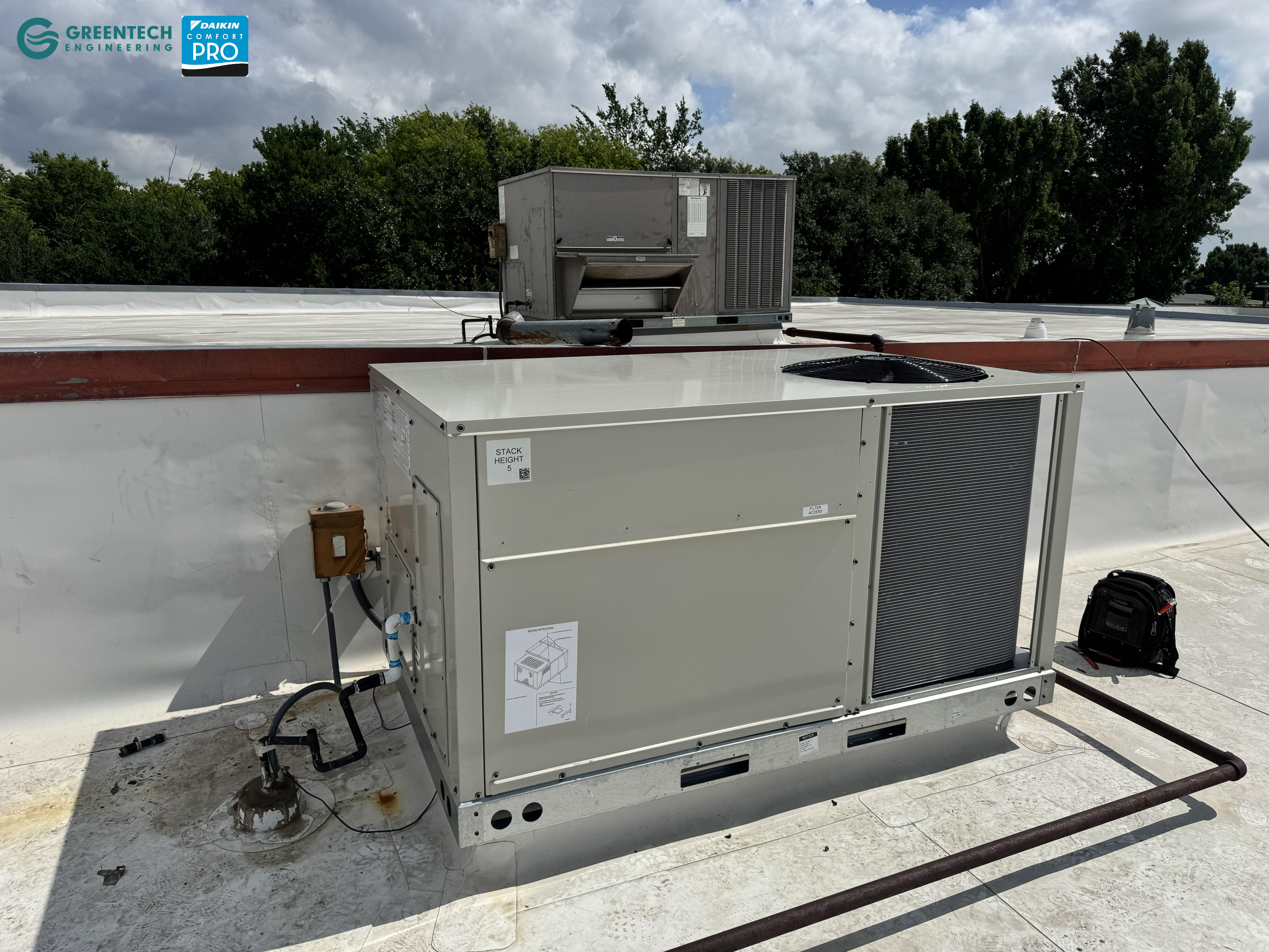 A side-angle view of the Daikin commercial rooftop unit showing the economizer integration and robust galvanized steel cabinet.