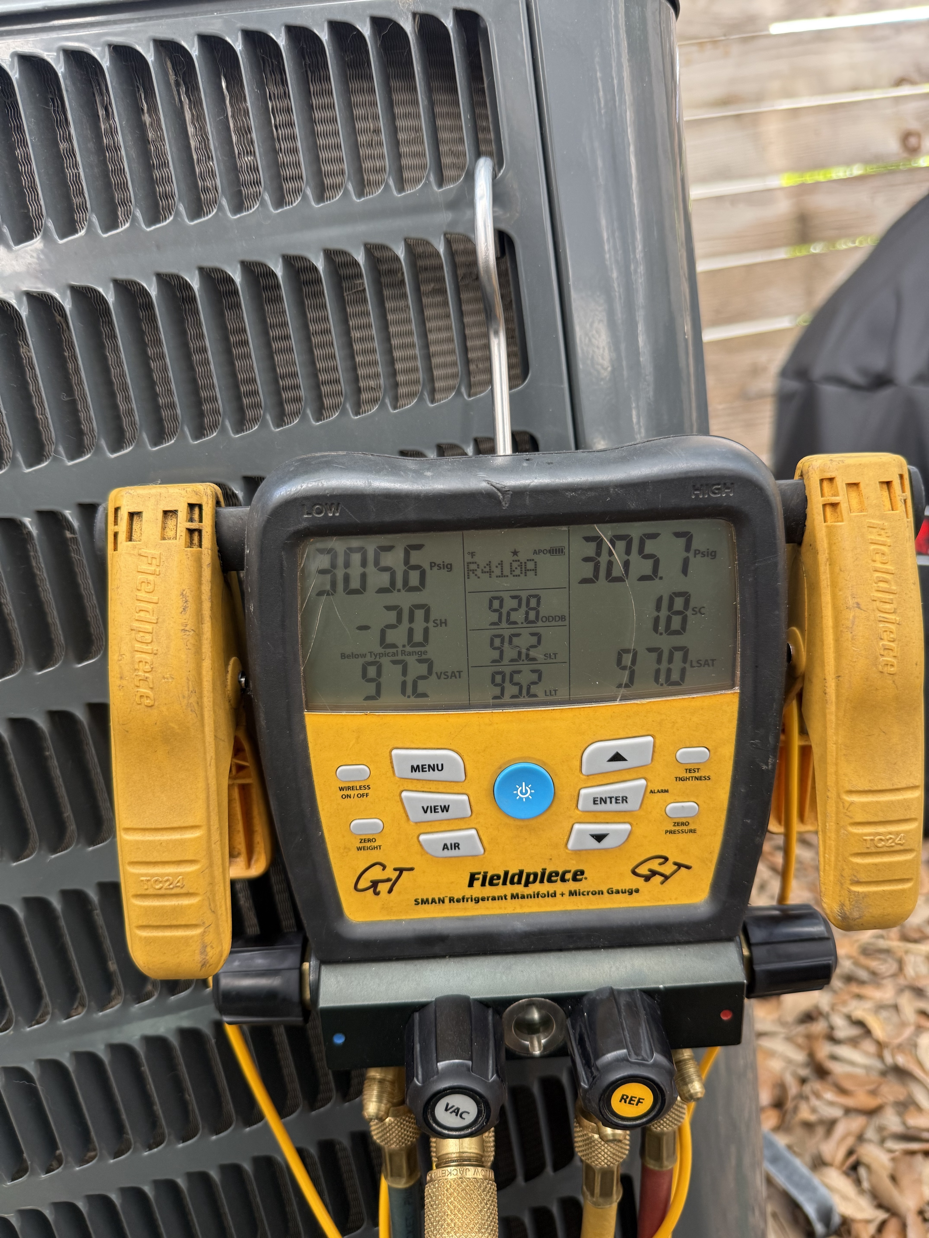 A digital Fieldpiece SMAN manifold gauge hooked up to a Dallas HVAC condenser, reading precise R-410A refrigerant pressures and saturation temperatures.