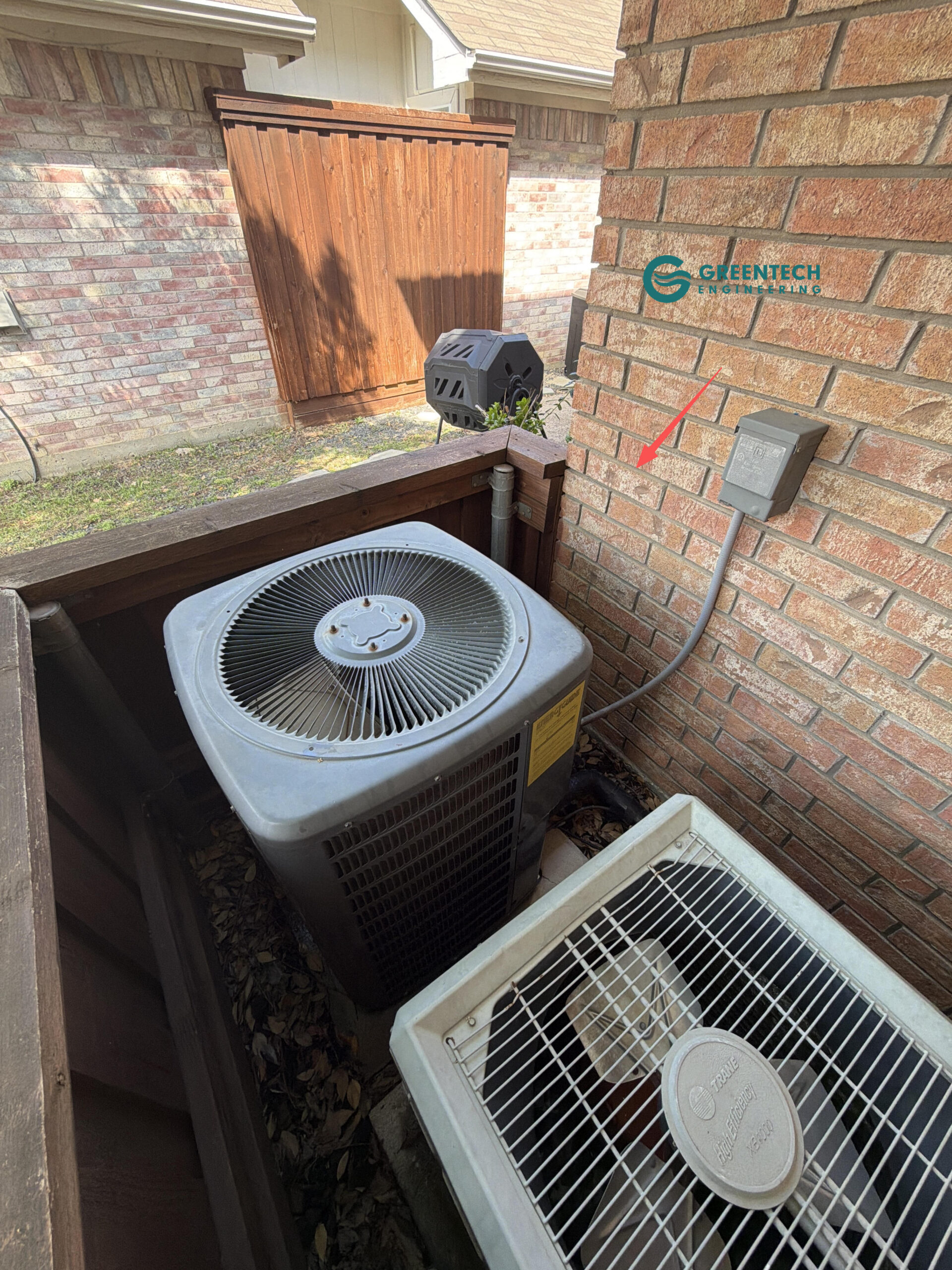 An aging, inefficient Trane AC condenser located on a second-story balcony of a Dallas brick home, slated for replacement before it fails.