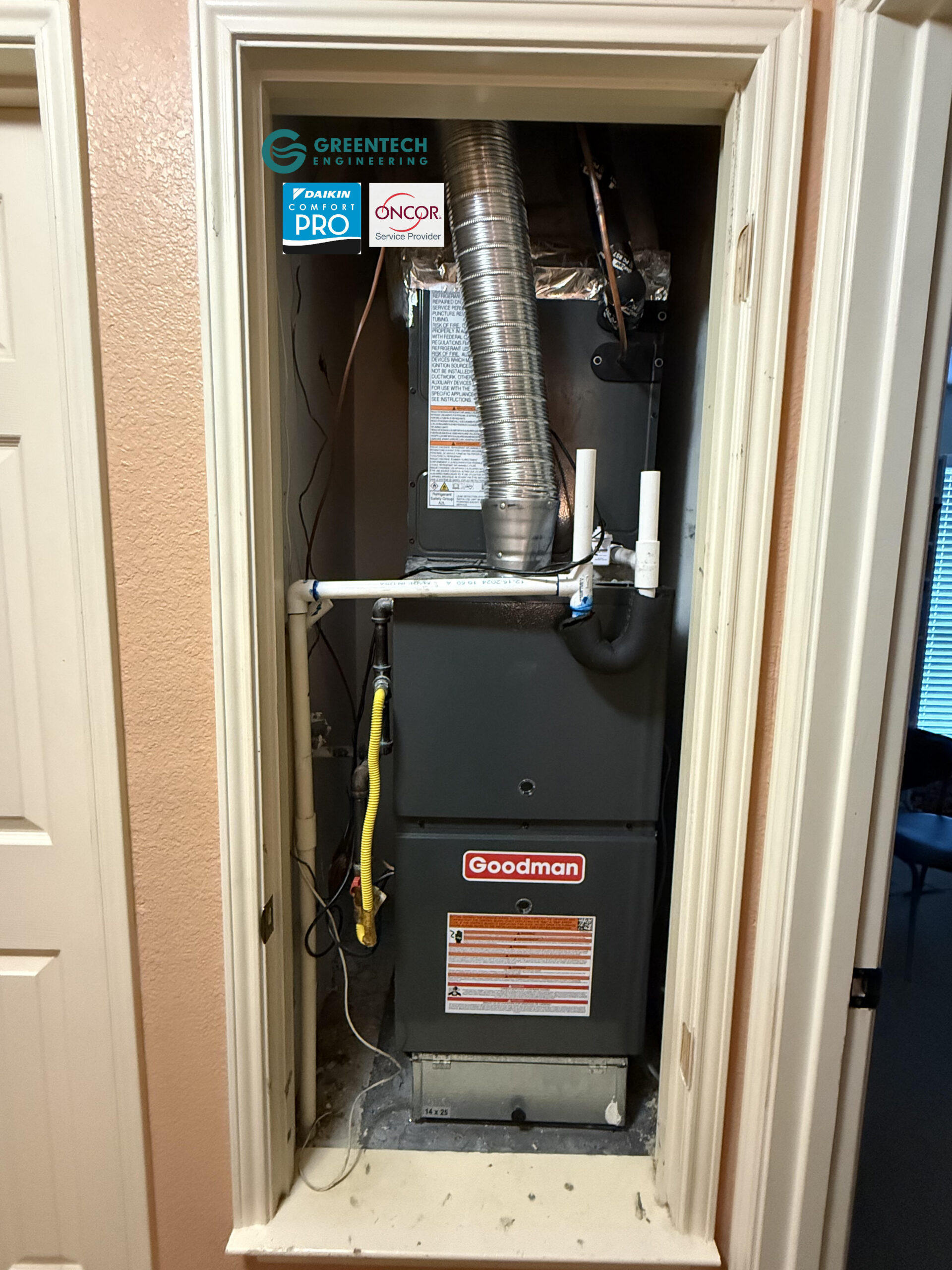 A brand new, highly efficient Goodman gas furnace and cased evaporator coil installed cleanly in a residential utility closet, featuring proper PVC drain lines and safety switches.