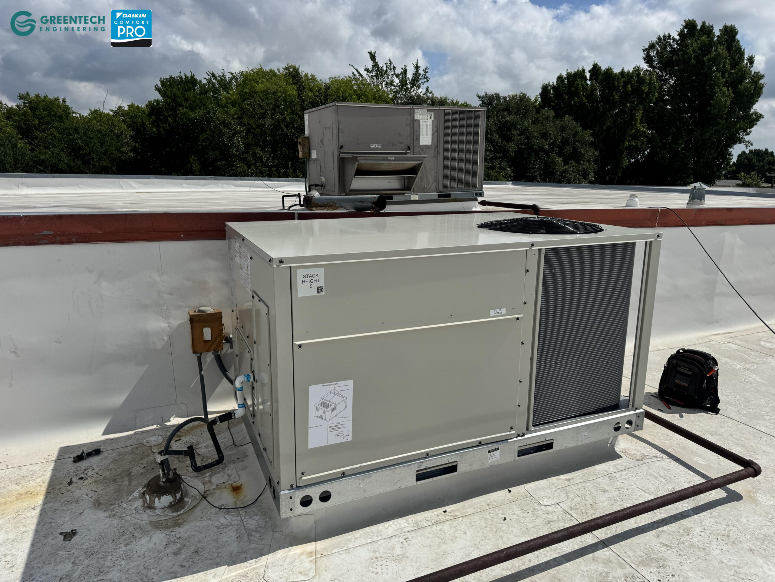 A side-angle view of the Daikin commercial rooftop unit showing the economizer integration and robust galvanized steel cabinet.