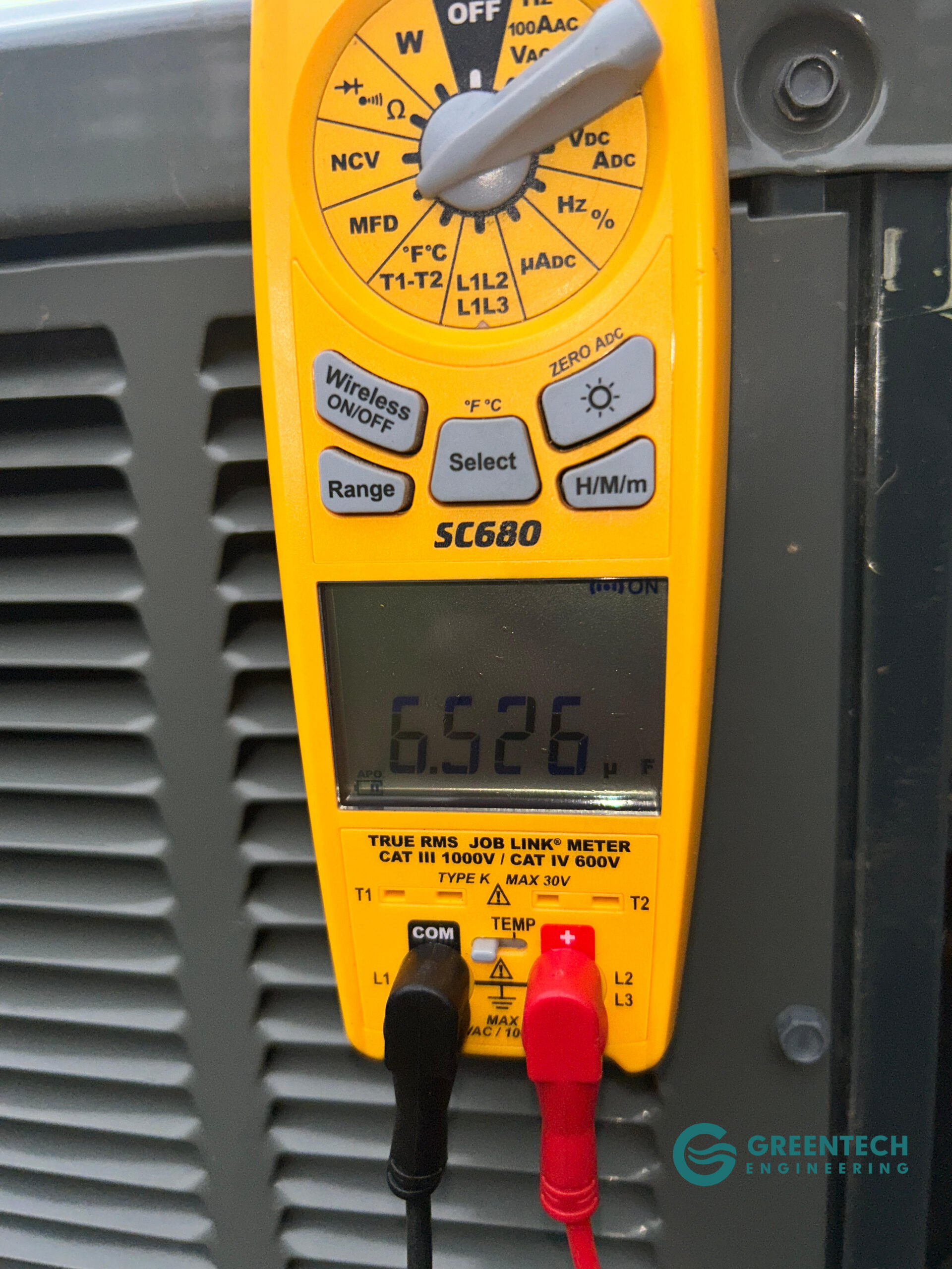 Greentech Engineering technician using a digital multimeter to prove an AC capacitor has failed below its operating range in Little Elm, TX.