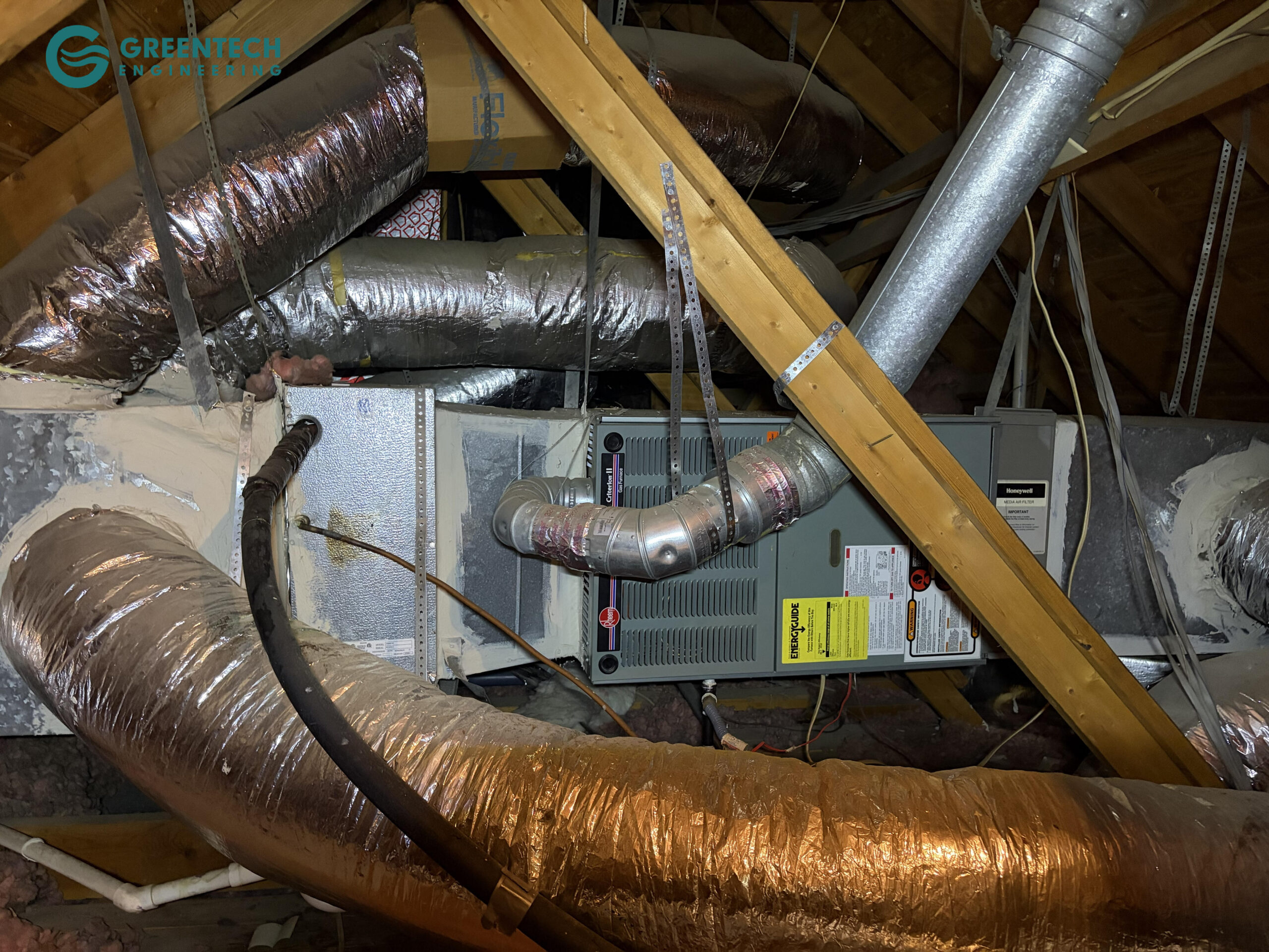 An older, inefficient gas furnace and evaporator coil setup in a hot Dallas attic with degrading ductwork connections.