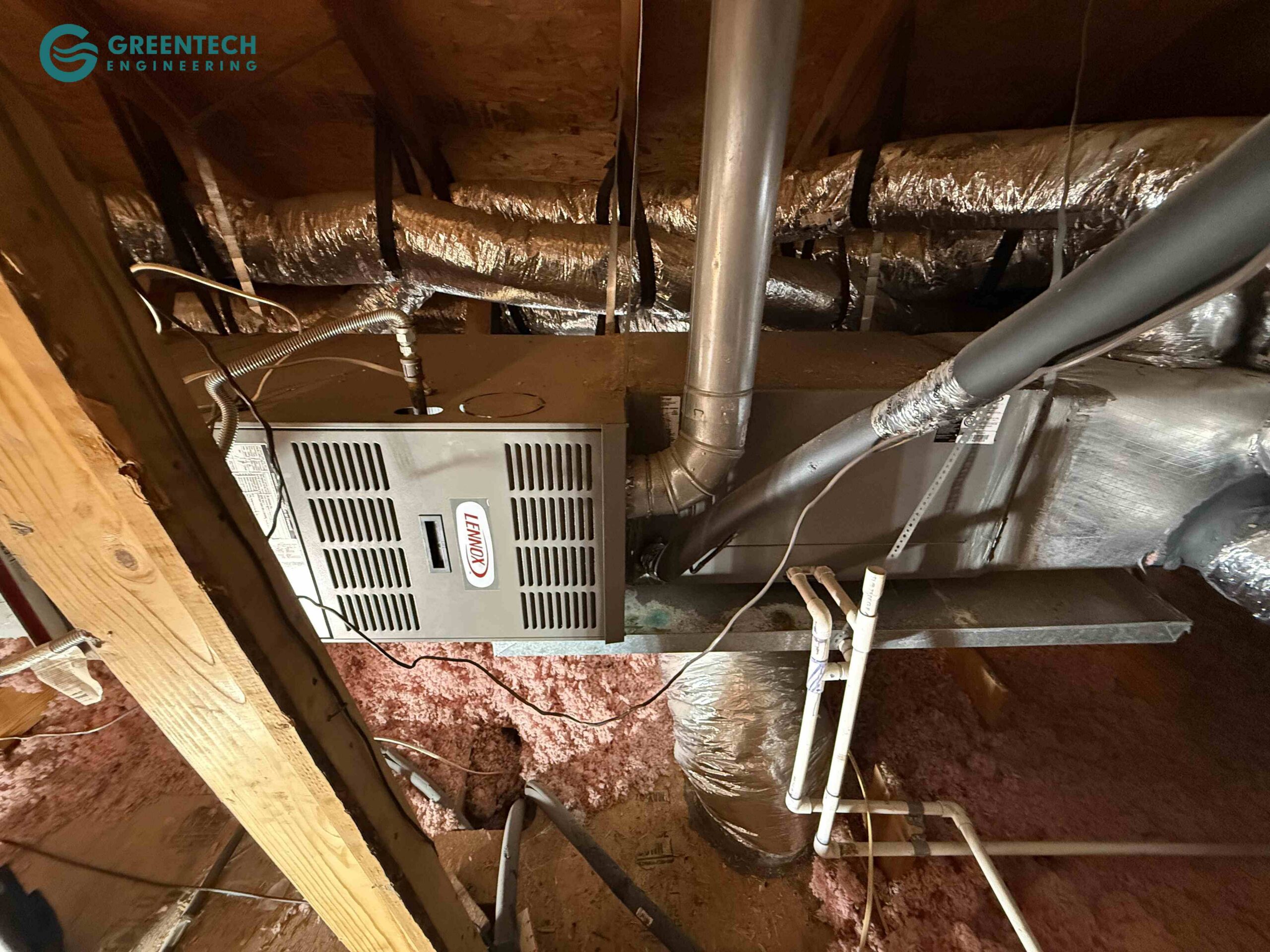 An older Lennox horizontal gas furnace and evaporator coil installed in a residential attic with aging ductwork connections.