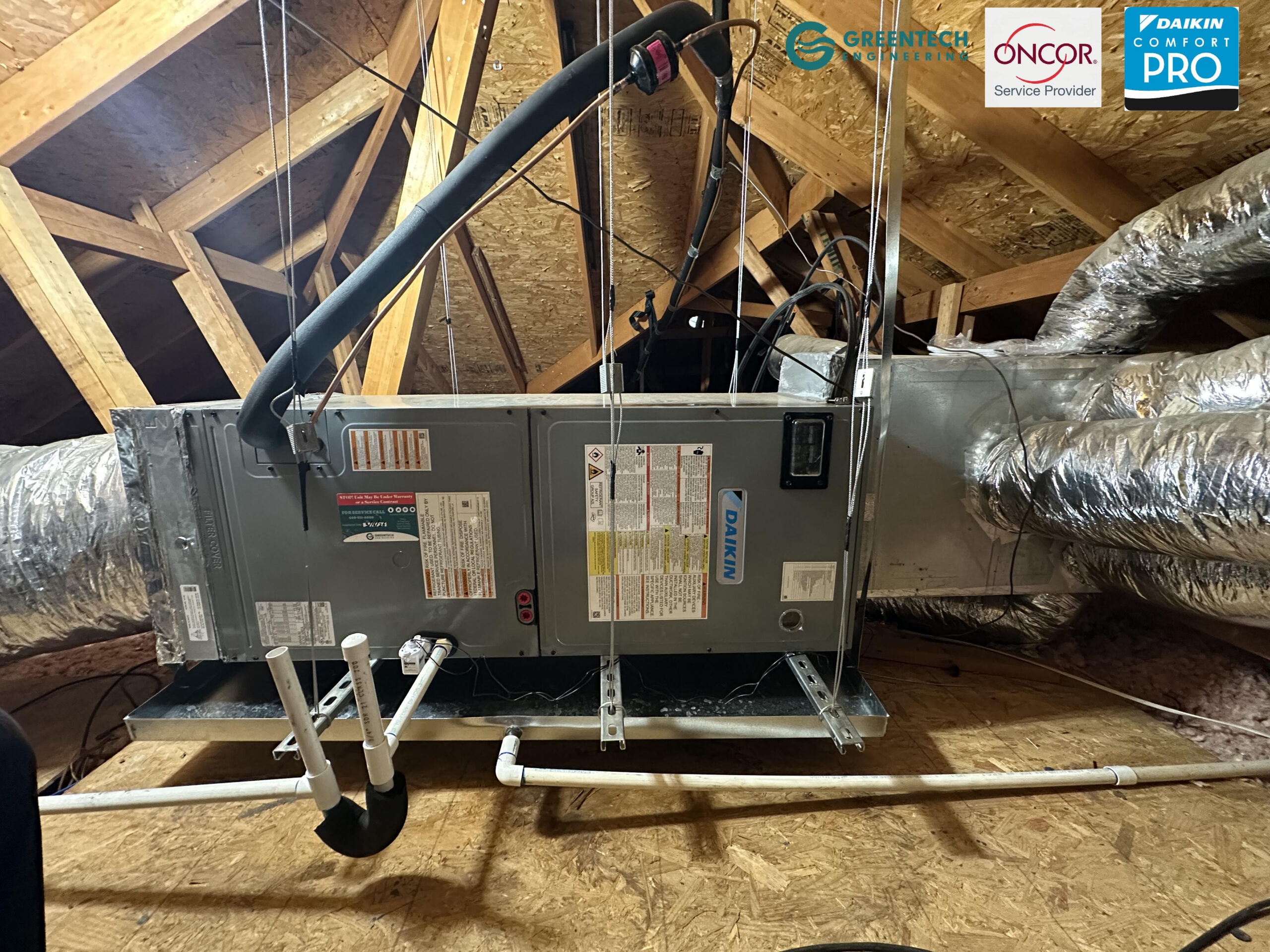 Newly installed Daikin variable speed air handler suspended securely in an attic with insulated ductwork.