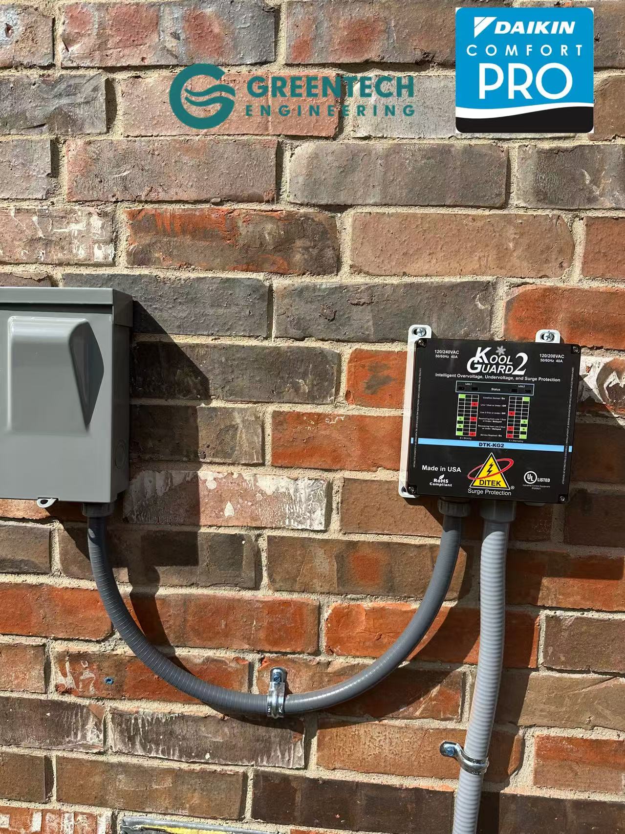 Close-up of a Kool Guard 220v voltage monitor and HVAC surge protector professionally installed on an exterior brick wall next to a disconnect box.