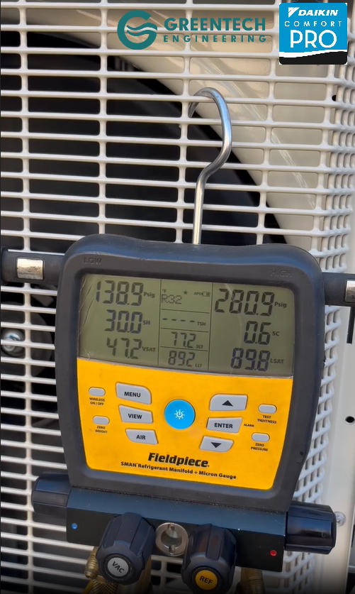 A Greentech Engineering technician using Fieldpiece digital manifold gauges to precisely charge a new Daikin variable-speed heat pump in Dallas, TX.