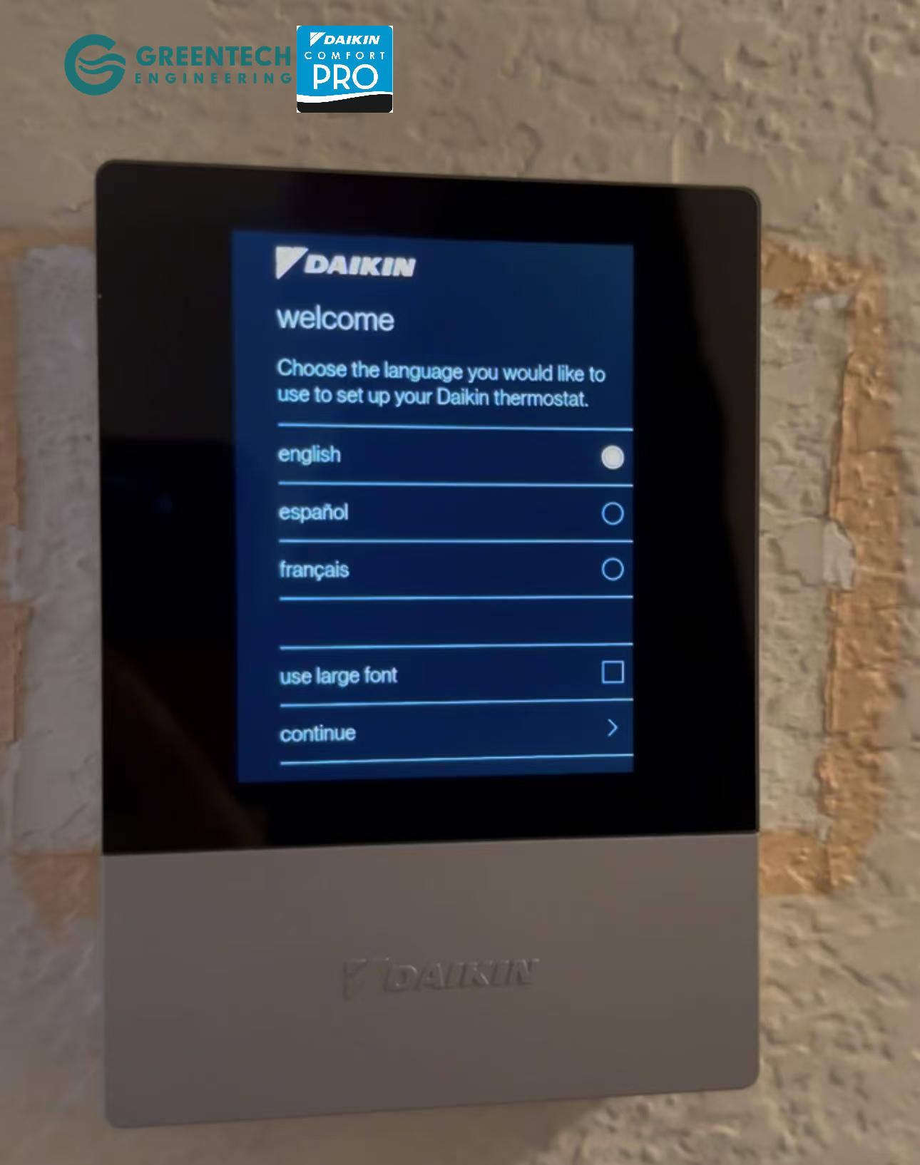 A close-up of the elegant, high-resolution screen of the Daikin One+ Smart Thermostat mounted on a wall in an Uptown Dallas home.