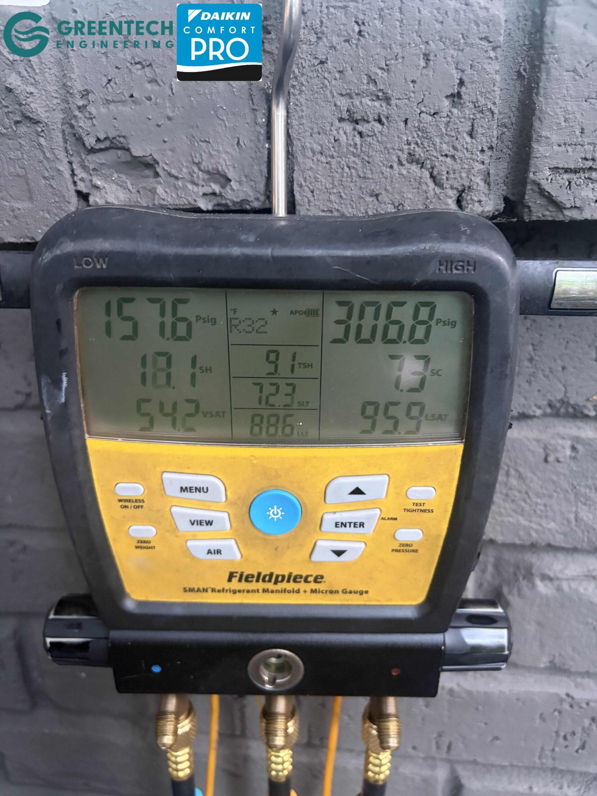 A digital Fieldpiece SMAN manifold gauge hooked up to a Dallas HVAC system, reading precise refrigerant pressures and micron levels.