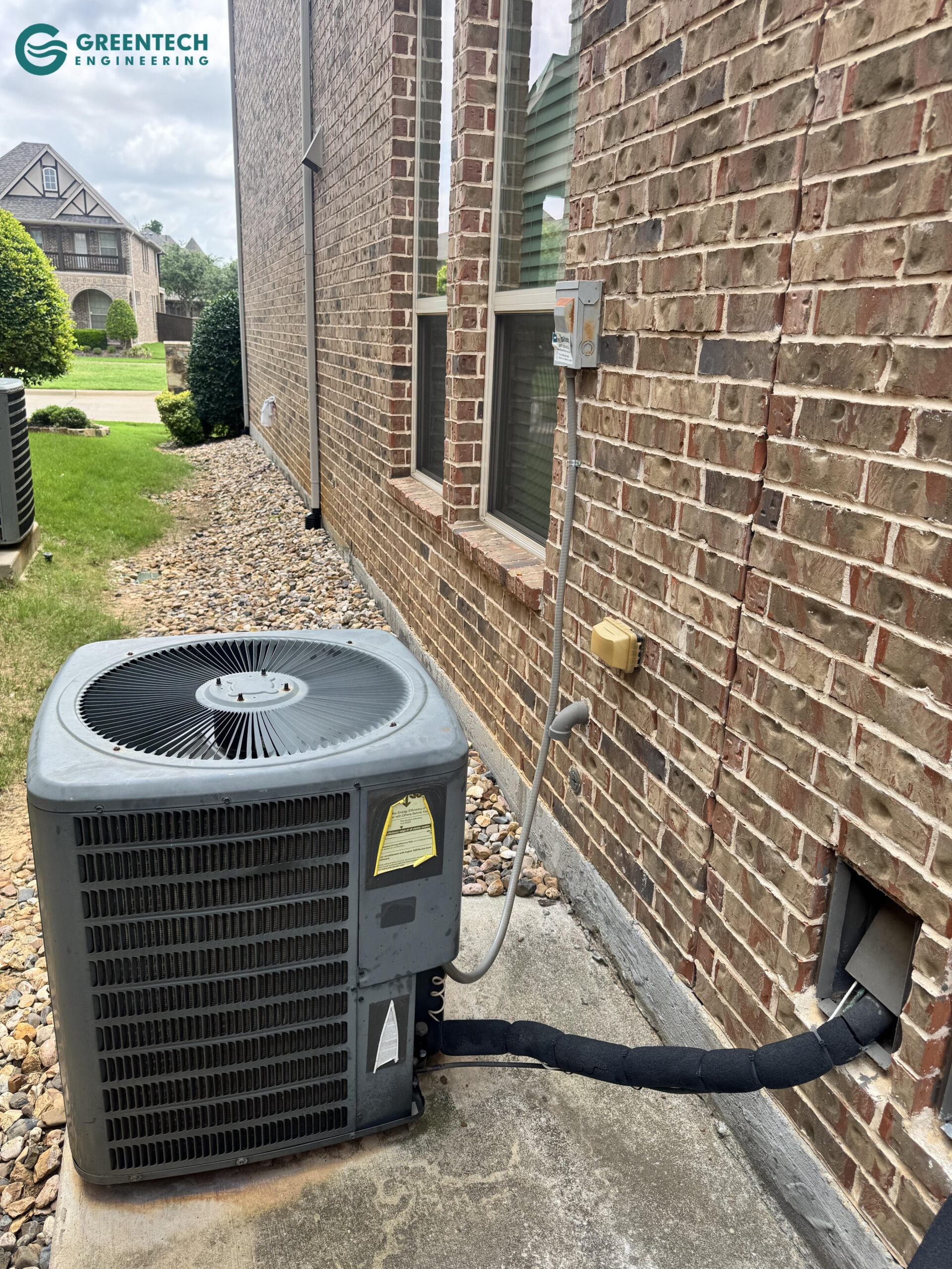 An aging, low-efficiency air conditioning condenser sitting against a brick exterior in Dallas, Texas.